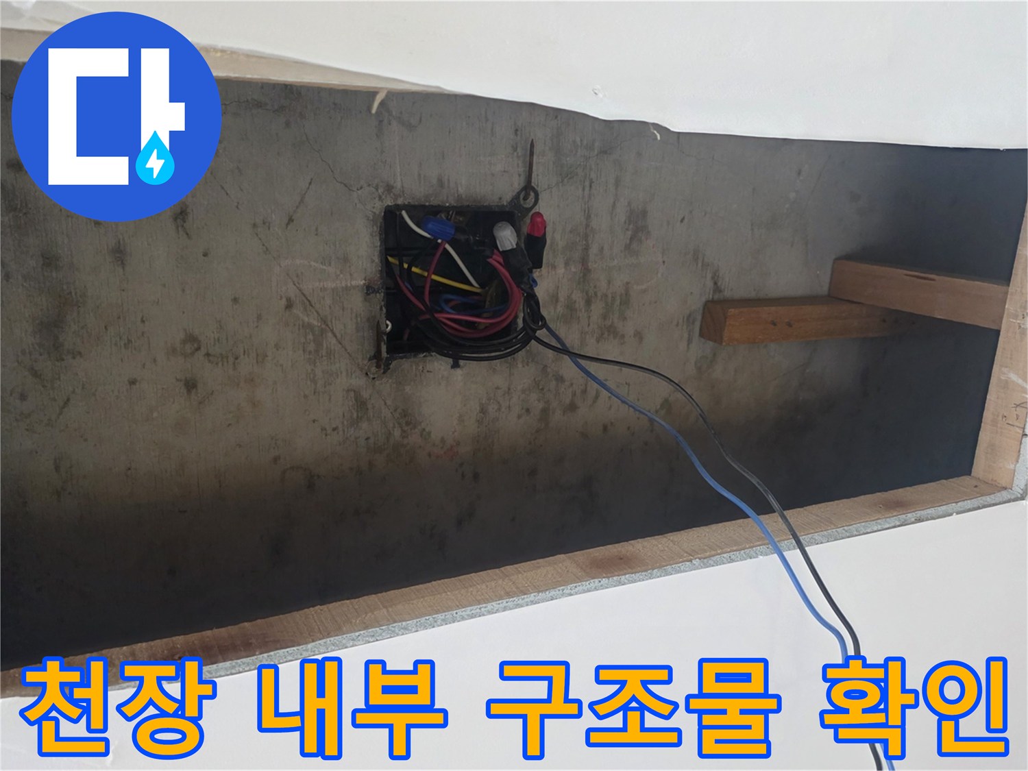 천장 개구부를 통해 보이는 전선 박스와 목재 보 구조물