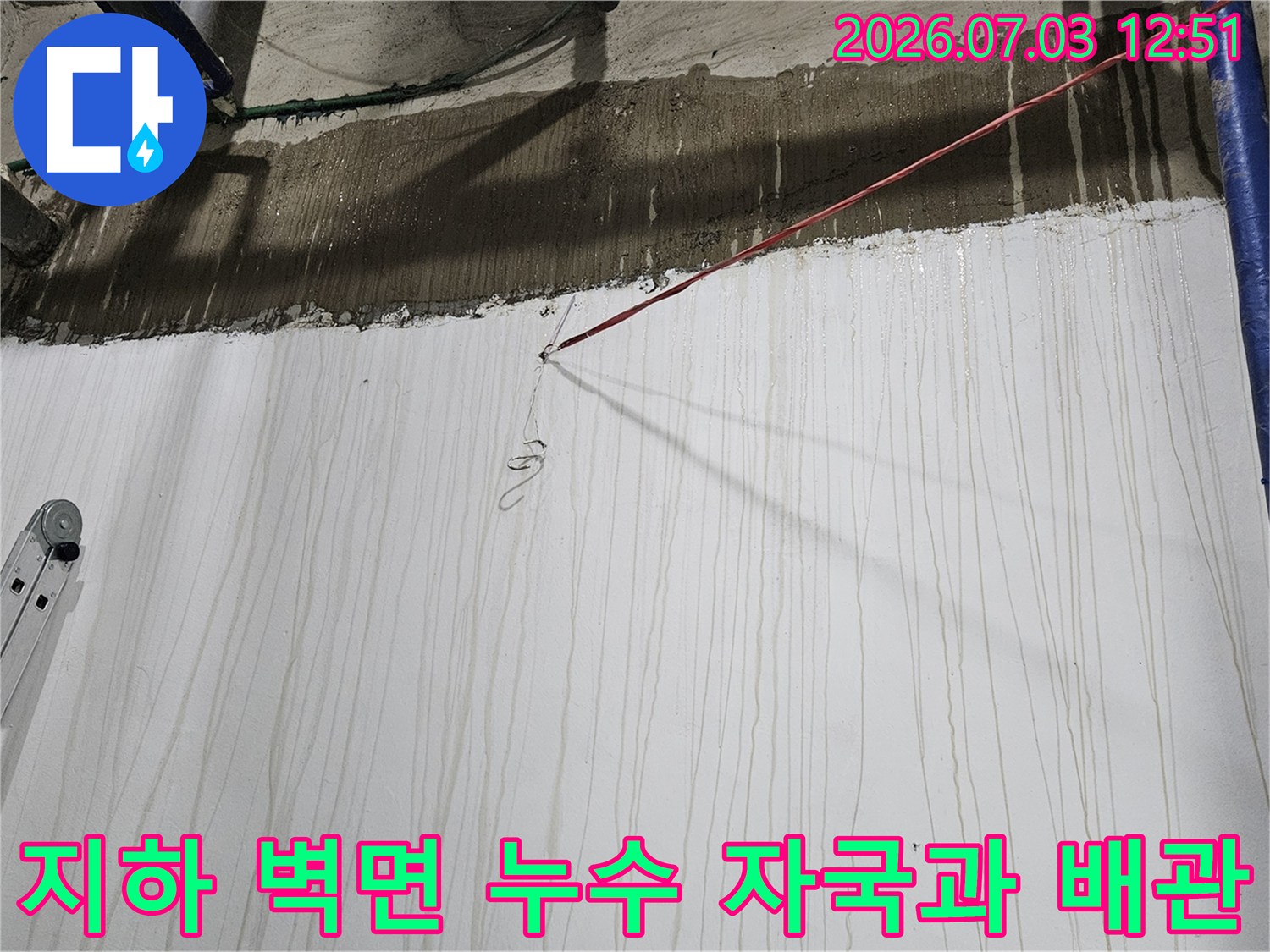 지하 공간-콘크리트 벽면에 물이 흘러내린 얼룩과 파란색 보온재 배관 사진