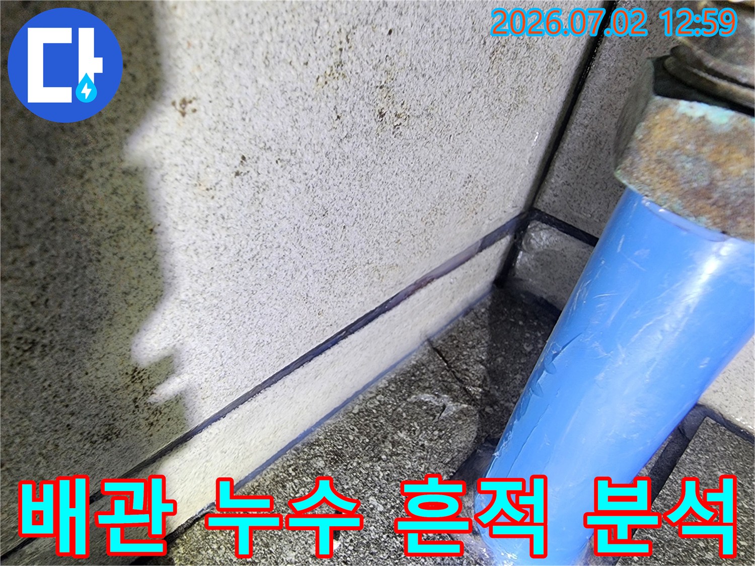 파란색-배관-주변에서-발견된-누수-흔적을-누수-전문가가-정밀하게-분석하는-모습을-담은-사진