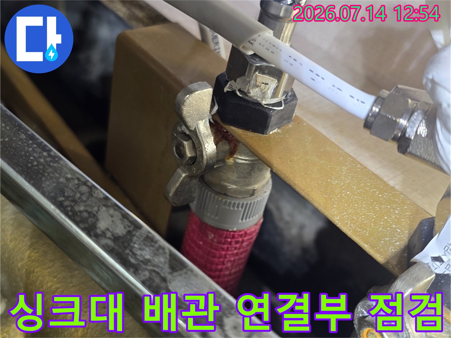 싱크대 하부의 노출된 수도 배관과 밸브 연결 부위 점검 모습