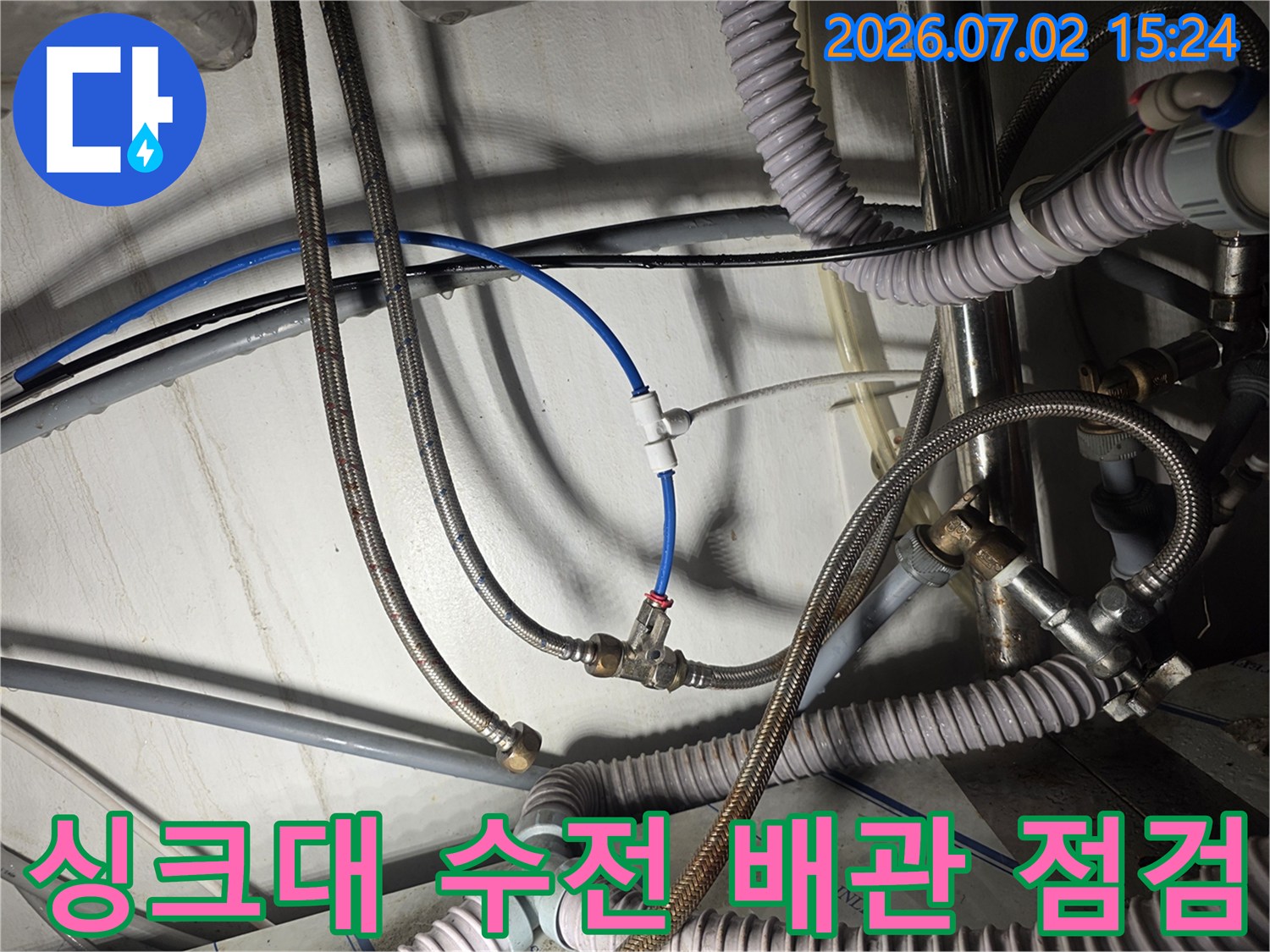 싱크대 하부의 노후된 급수 호스 및 연결 부위 점검 사진
