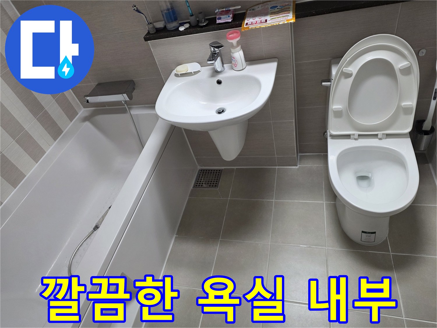 정돈된 상태의 화장실 변기와 세면대 주변부 사진입니다.