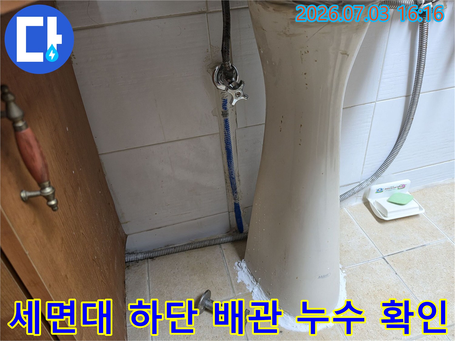 노출된 세면대 하부 배관과 연결 부위의 물때 및 변색을 촬영한 사진입니다.