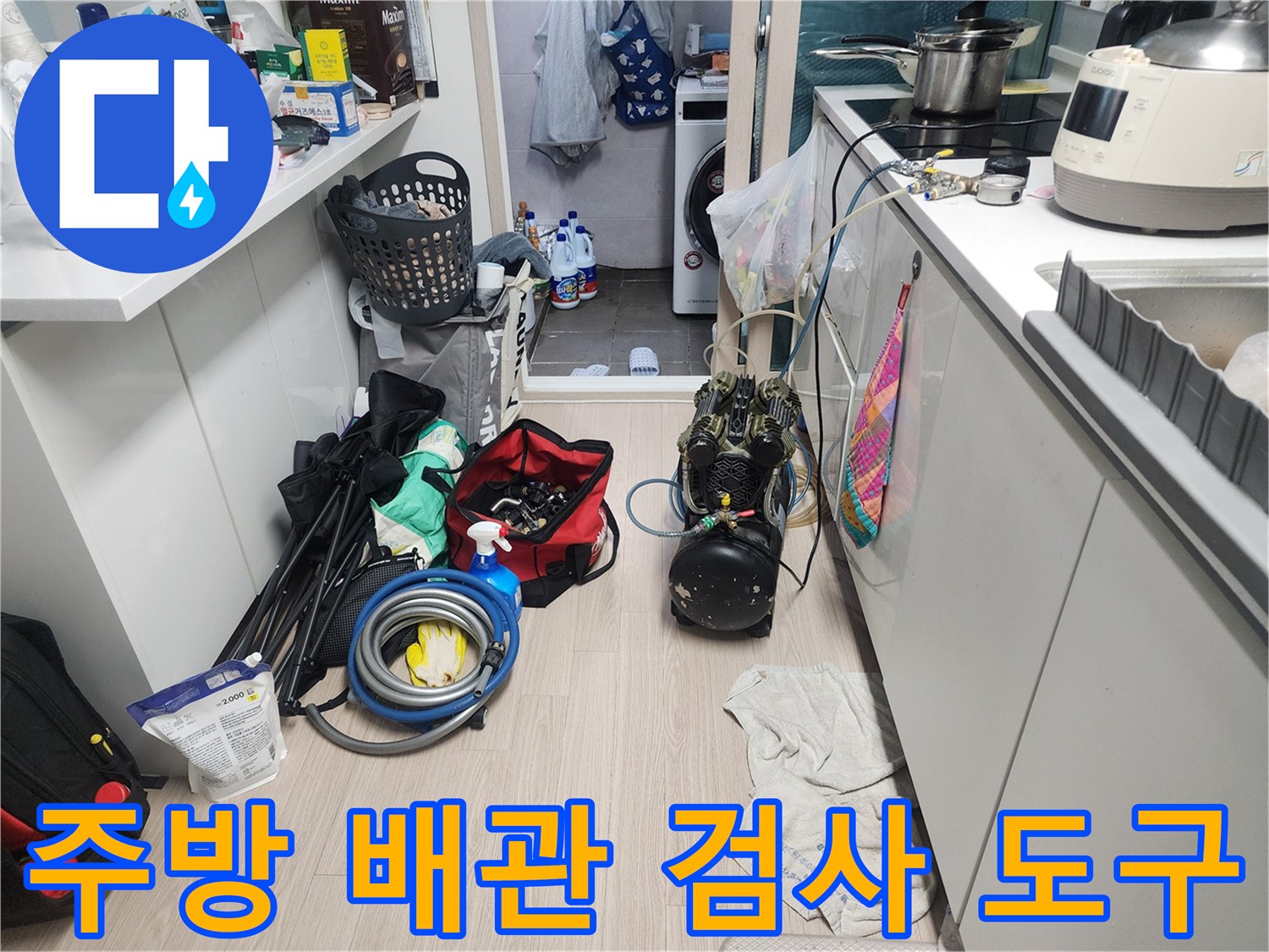 작업을 위해 싱크대 아래 바닥에 놓인 누수 탐지 장비 세트