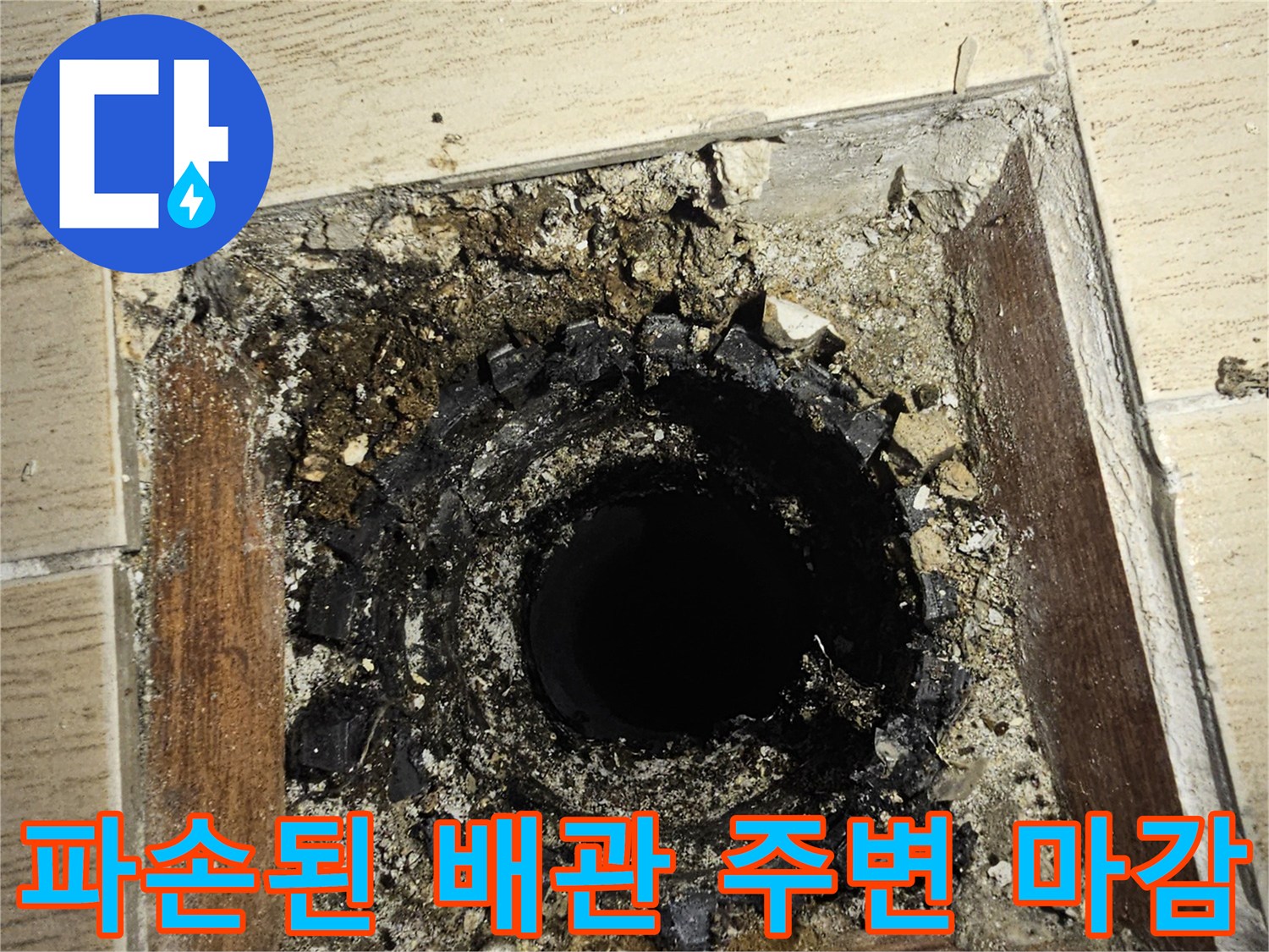 우수관 주변의 깨진 타일과 노출된 배관 부속