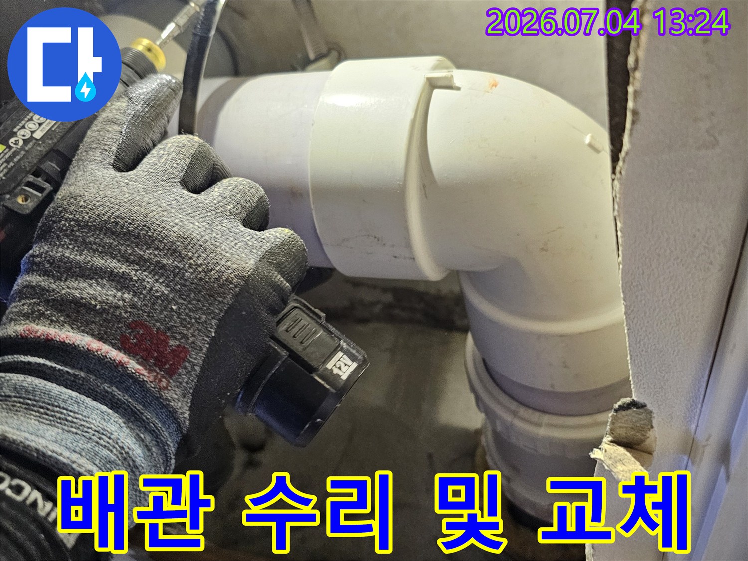 전문가용 장갑을 착용한 채 천장 배관의 연결 부위를 세심하게 작업하는 장면