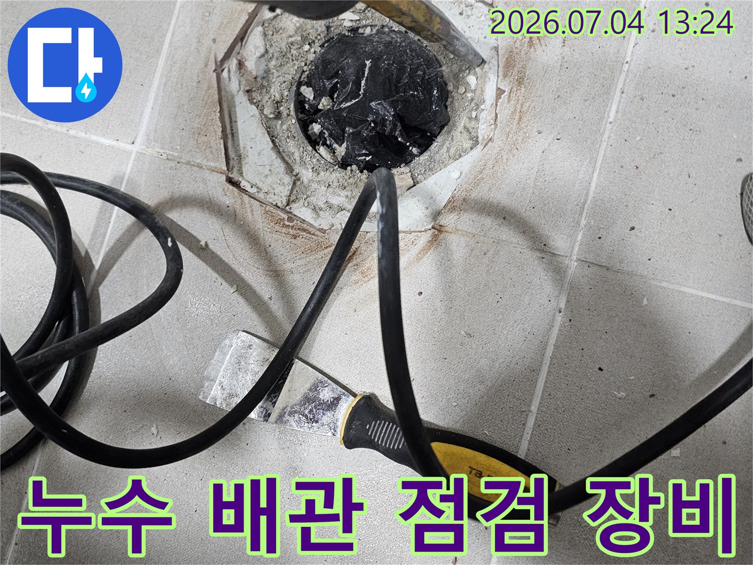 전문가용 탐지기를 노출된 배관에 연결하여 누수 지점을 정밀하게 확인하는 사진