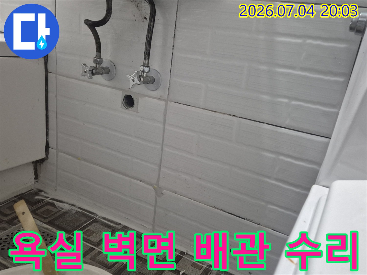 욕실 타일 벽면에 설치된 노출 배관과 연결 부위의 모습