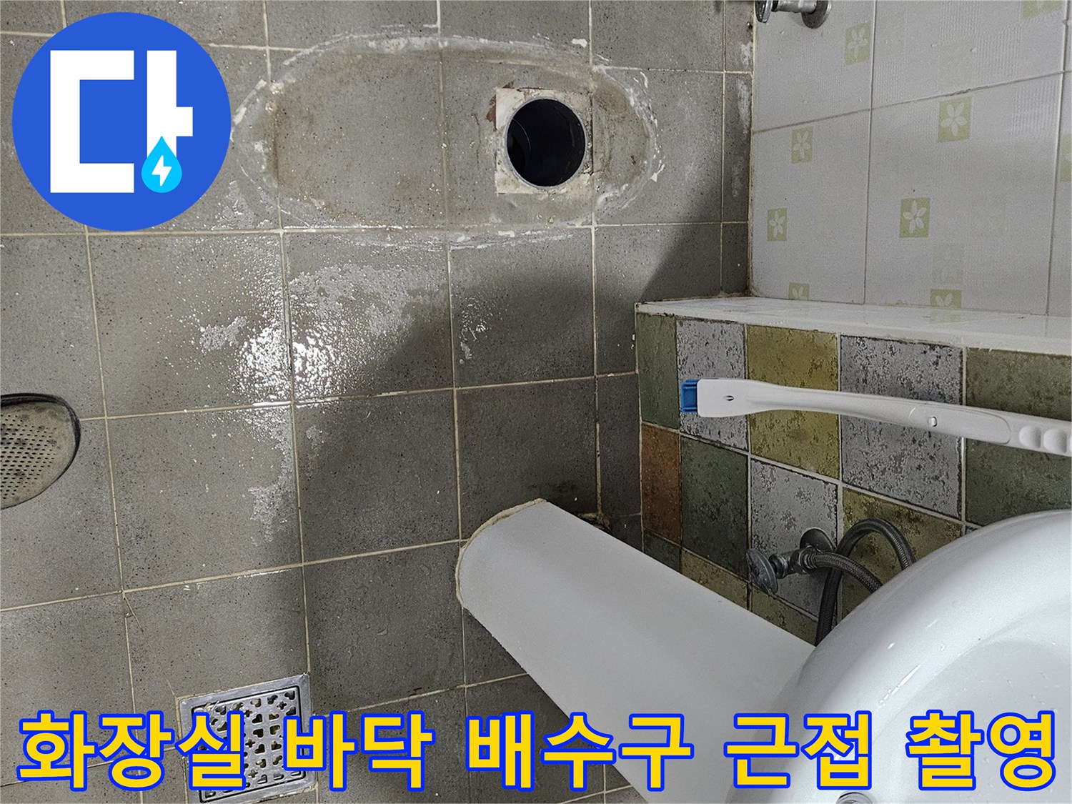 화장실 유가 주변의 타일 마감과 배수구 입구 모습입니다.