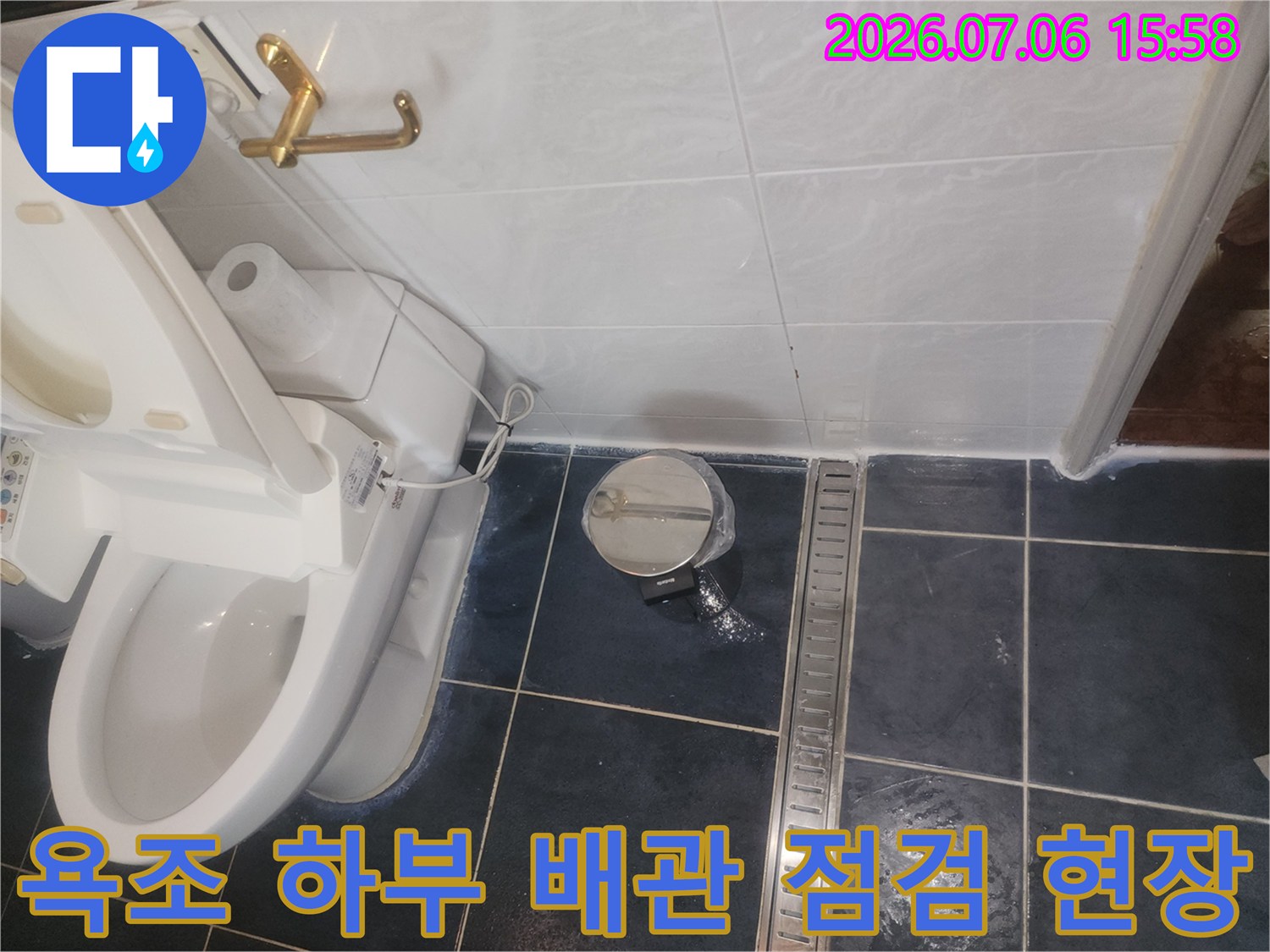 욕조 아래쪽으로 노출된 파이프와 밸브의 상태를 점검하고 있는 장면