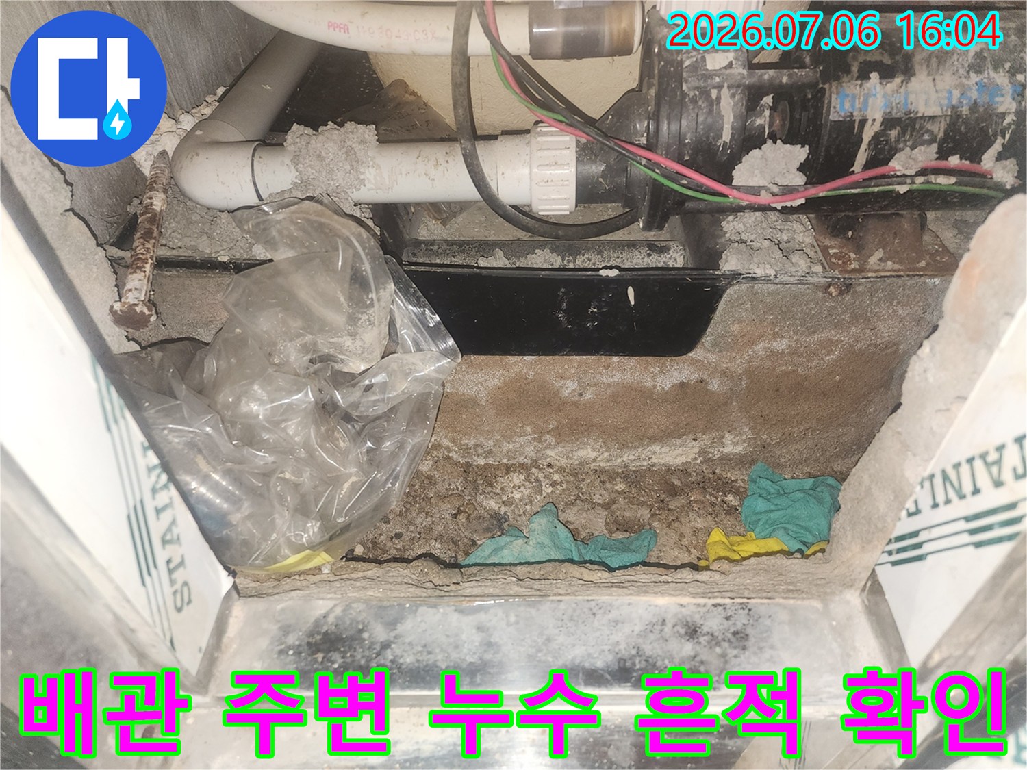 욕조 하부 배관 연결 부위의 물 고임과 노후 상태를 보여주는 사진입니다.