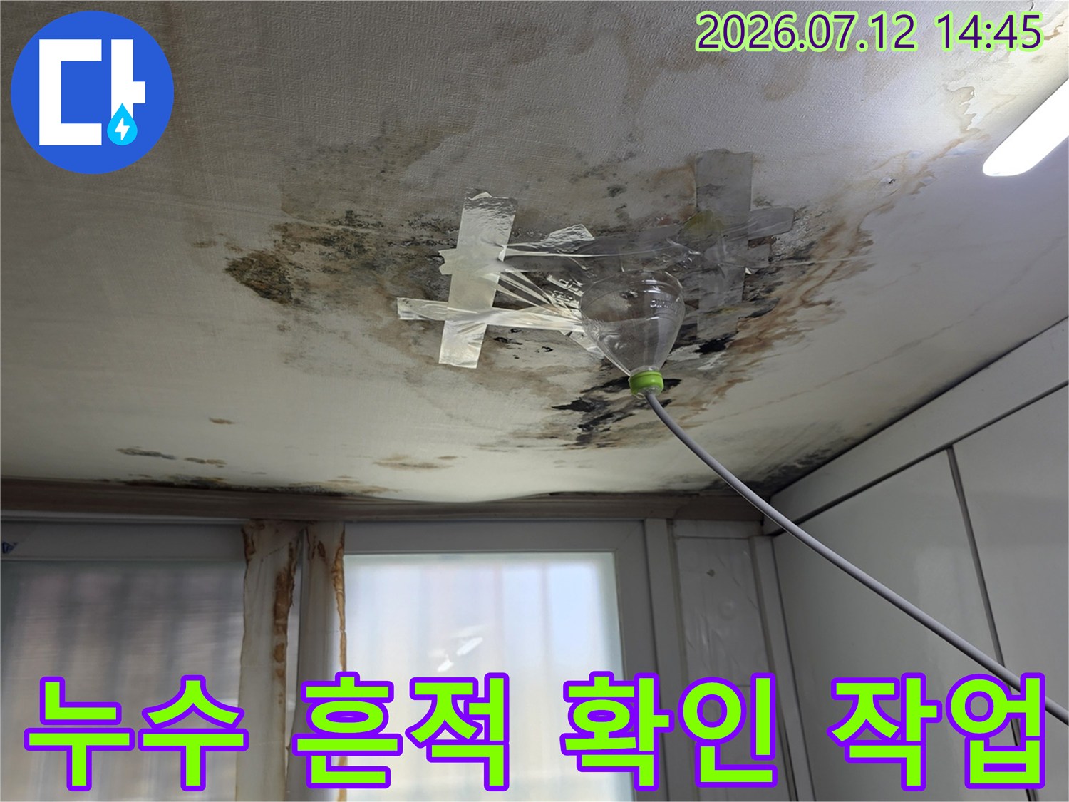 누수로 인해 젖고 오염된 천장의 전등과 배관 부근을 살피는 사진