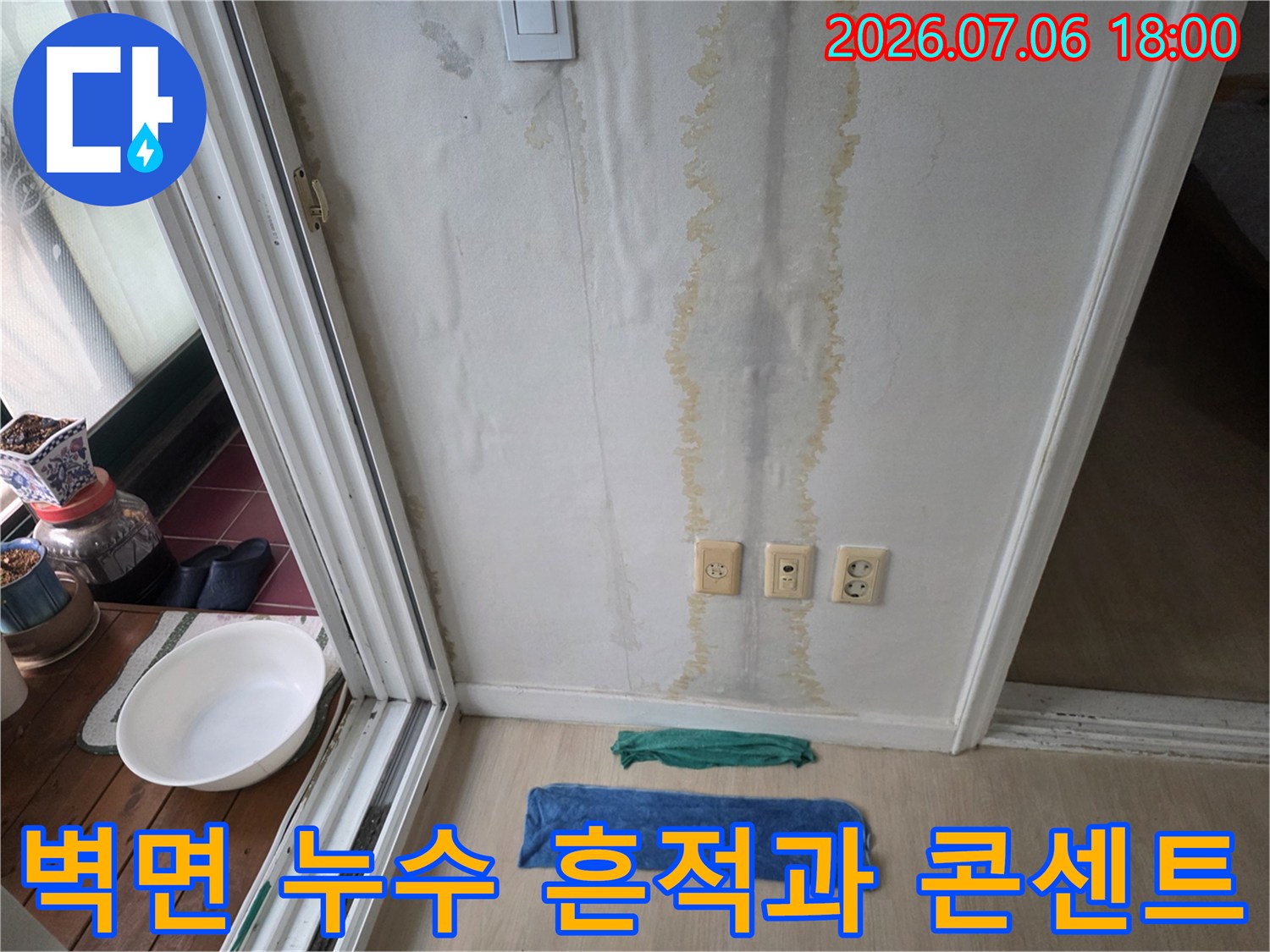 벽면에 발생한 누수 얼룩과 전기 콘센트가 위치한 현장 모습