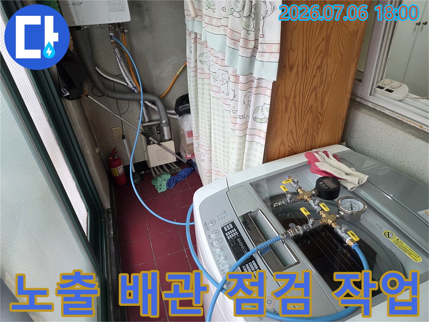 세탁실 내 노출된 파란색과 회색 배관의 연결 부위를 정밀하게 점검하는 모습