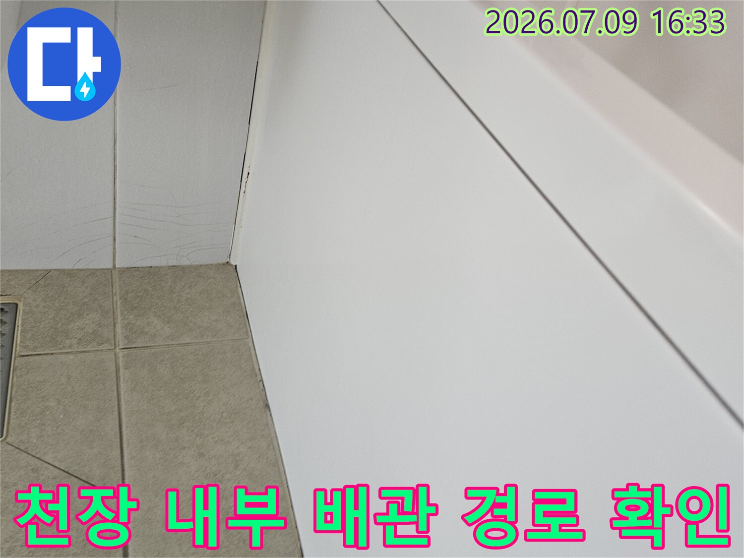 화장실 천장 안쪽을 개방하여 노출된 배관과 마감재를 촬영한 사진