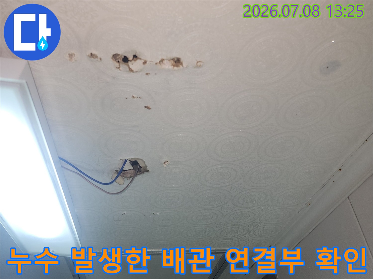 벽지에 얼룩이 남은 화장실 천장과 파손된 하수관 부속의 상세 모습