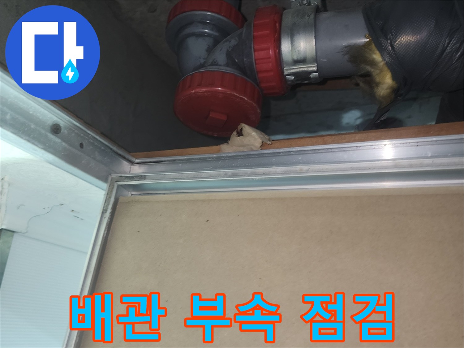 하수 배관의 붉은색 소재구와 금속 고정 장치 촬영
