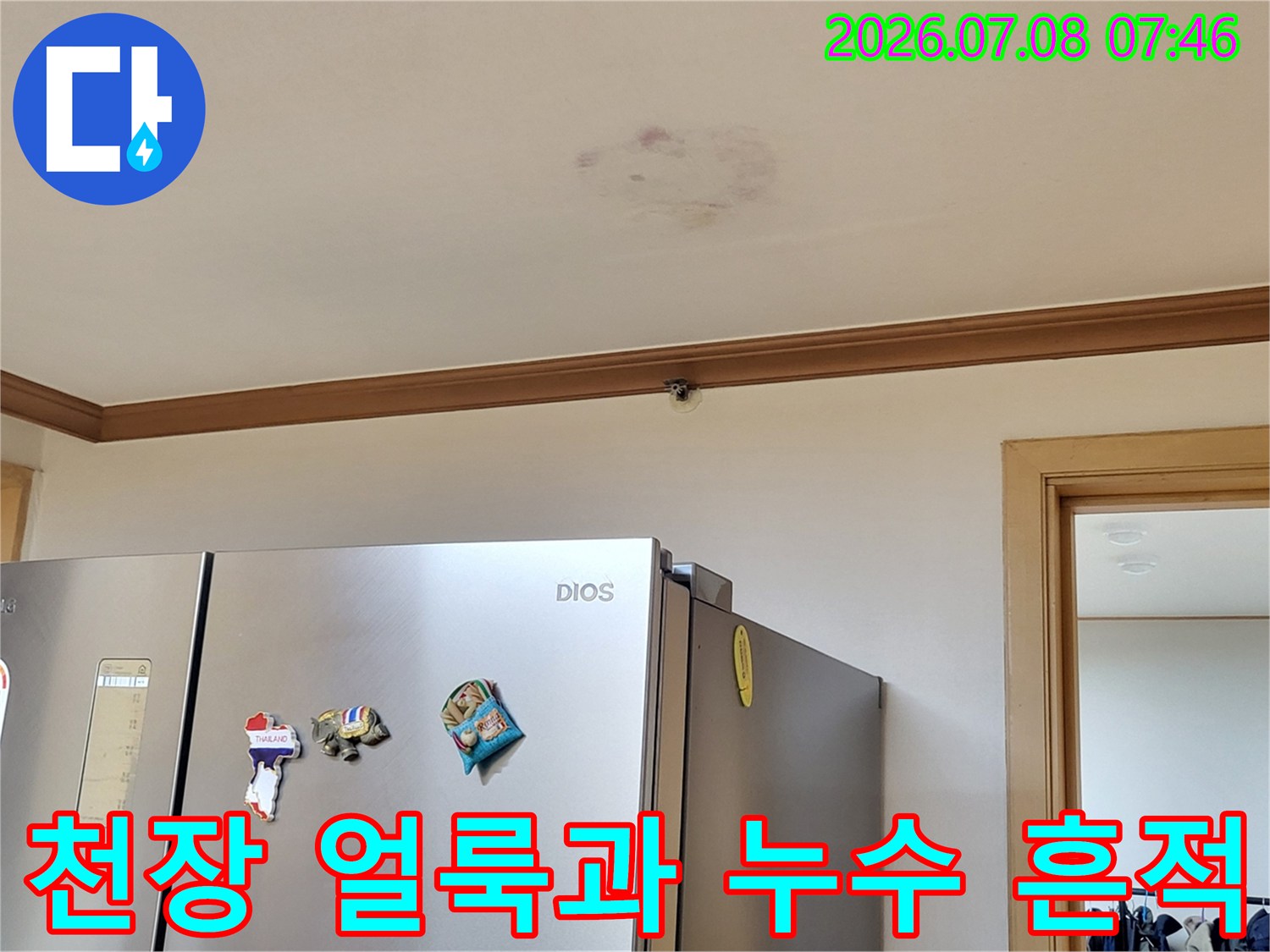 거실 천장에 남은 노란색 누수 얼룩의 상태를 촬영한 모습