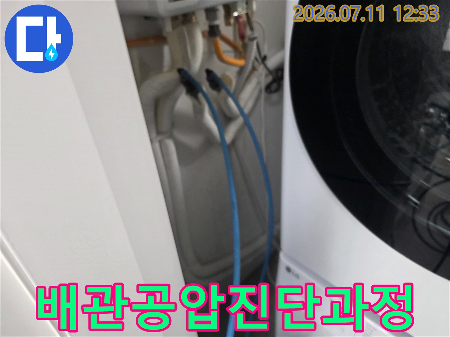세탁기 옆 공간에 연결된 파란색 호스를 이용한 배관 공압 진단 모습