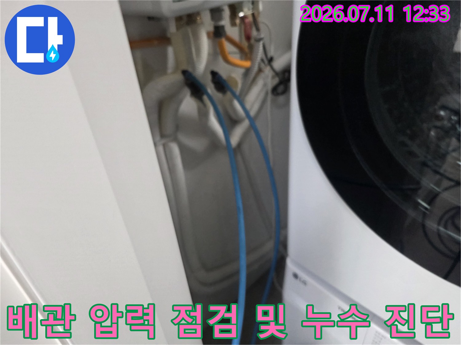 세탁기 옆 배관에 공압 호스를 연결하여 기밀 테스트를 진행하는 모습