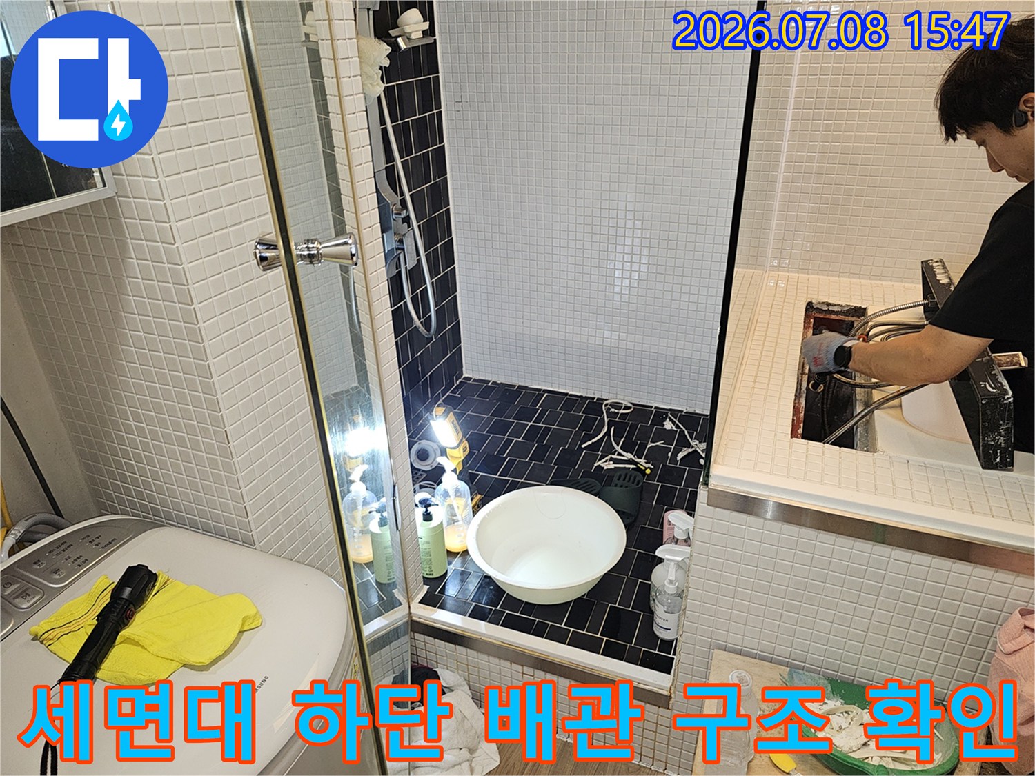 배수 트랩과 세면대 연결 부위의 파손 및 방수 결함 여부를 점검하는 모습