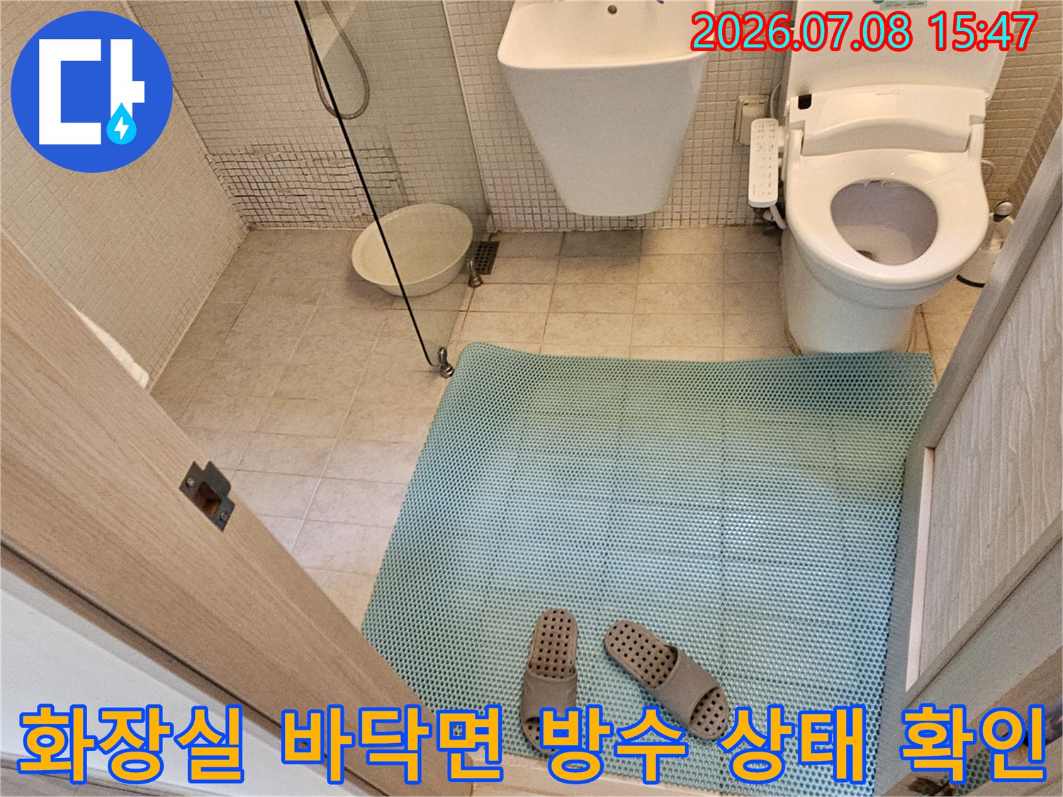 파란색 매트 위에서 변기 및 세면대 주변 배관을 점검하는 현장 사진