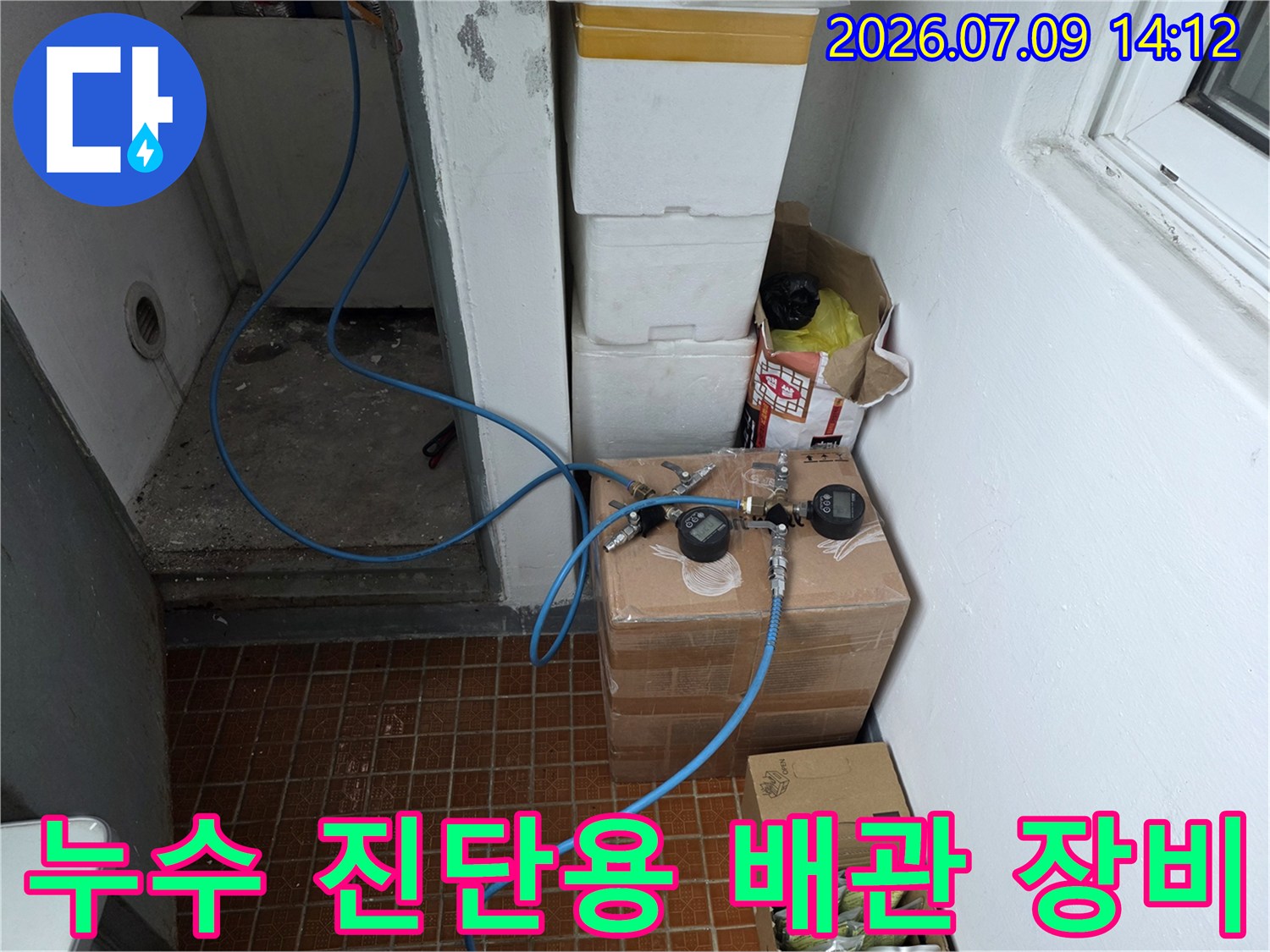 배관 공압 테스트를 위해 연결된 파란색 호스와 측정기