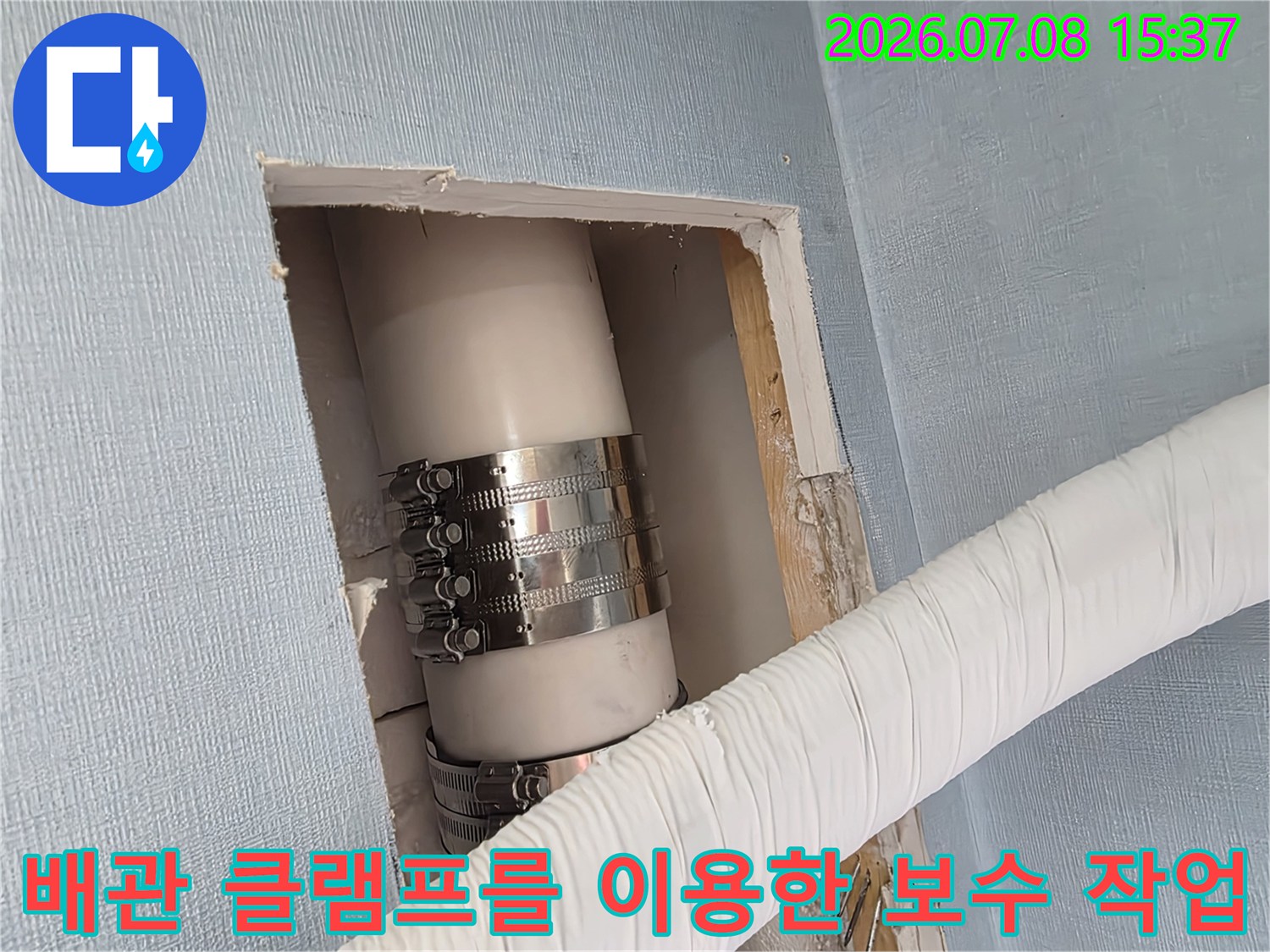 금속 밴드로 단단히 조여진 배출용 배수관의 연결부위 확대 사진