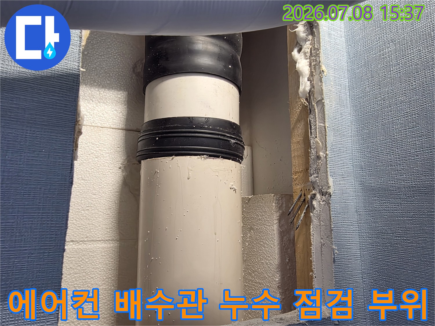 벽면을 절개하여 노출된 에어컨 배수관과 연결부 보수 현장