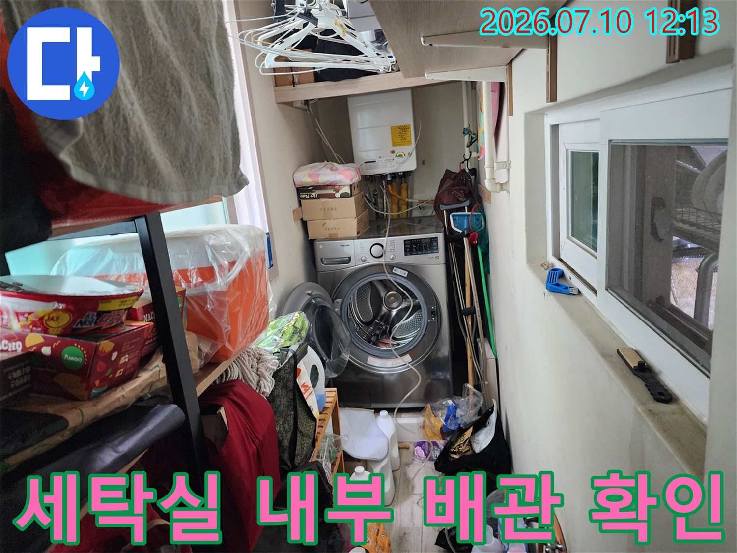 세탁기 옆 노출 배관과 세제통 등이 있는 공간의 모습