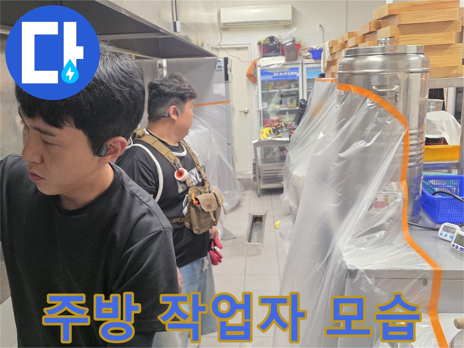 식당 주방에서 배수관 점검을 진행 중인 엔지니어의 모습입니다.