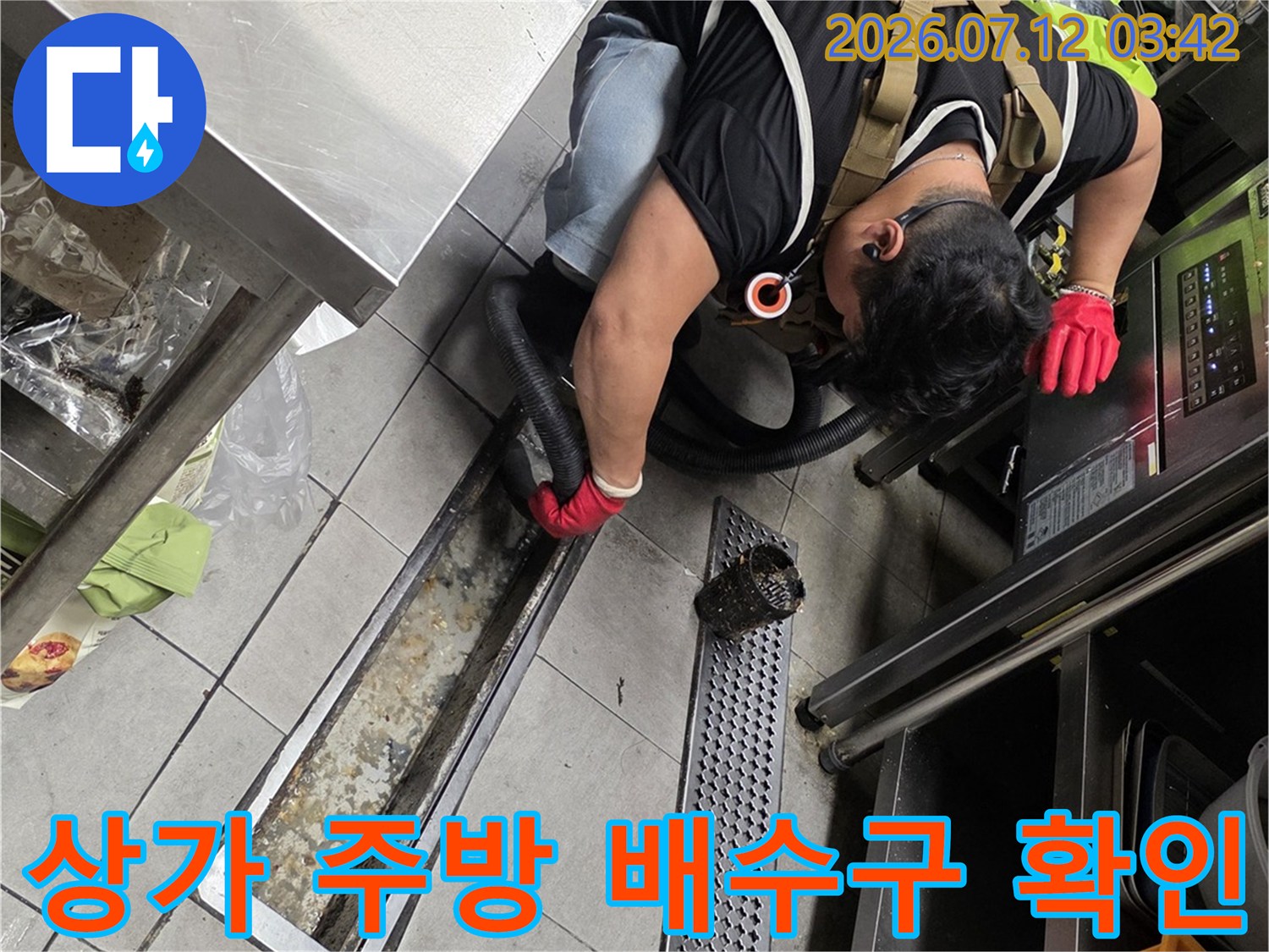 작업자가 상업용 주방의 트렌치 배수구를 점검하는 모습
