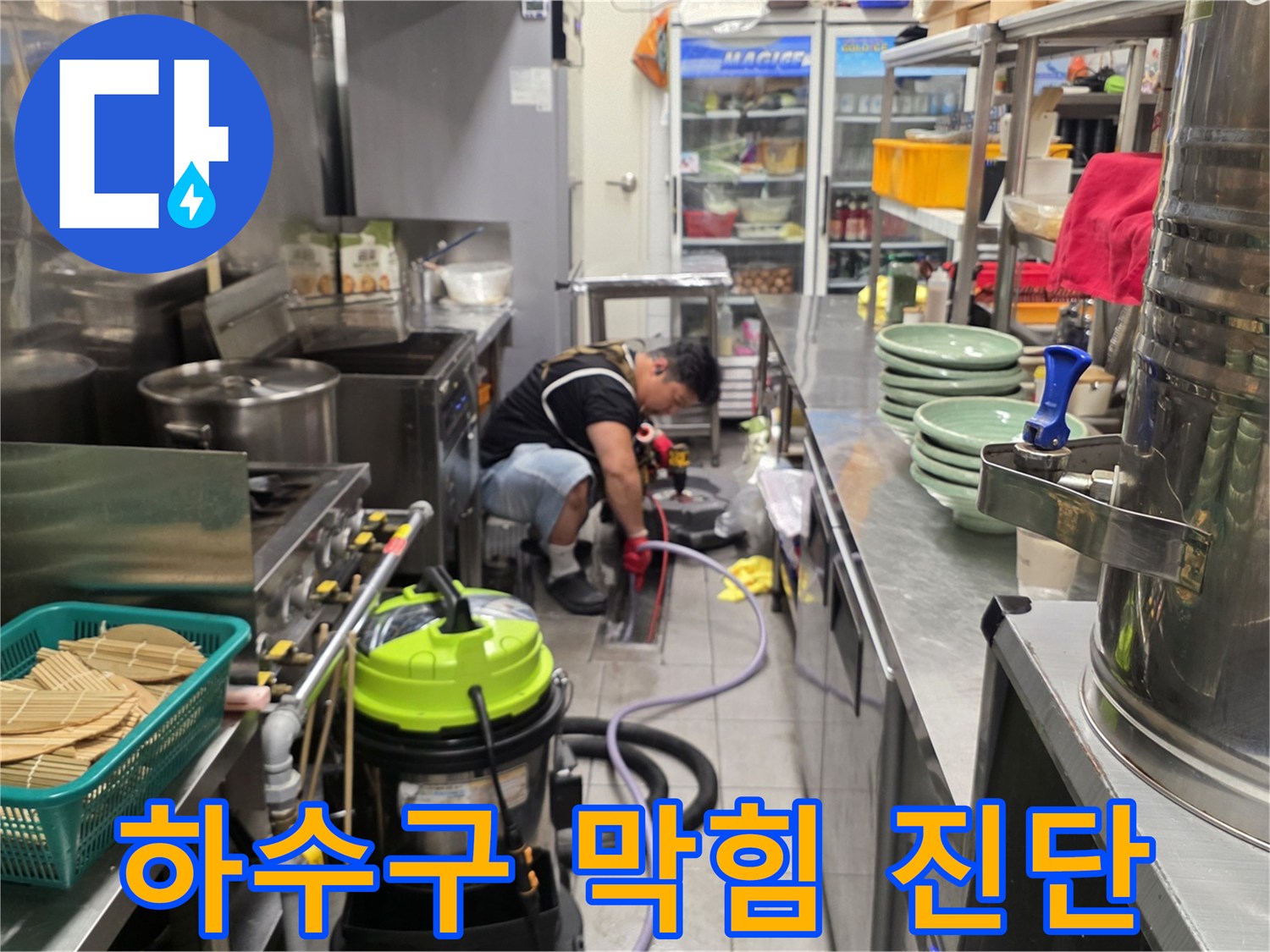 주방 설비 아래쪽에서 진행되는 하수구 막힘 상태 점검 작업