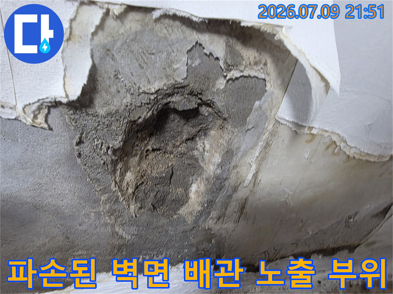 파손되어 훼손된 벽면의 내부 배관과 마감재가 노출된 현장 모습