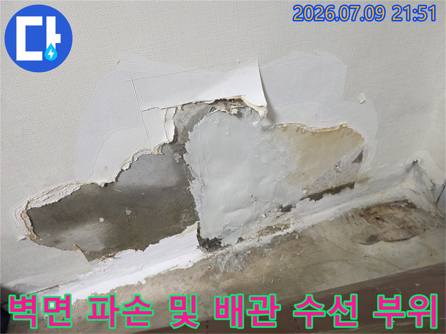 파헤쳐진 벽면 내부를 드러낸 누수 지점의 배관 수리 현장