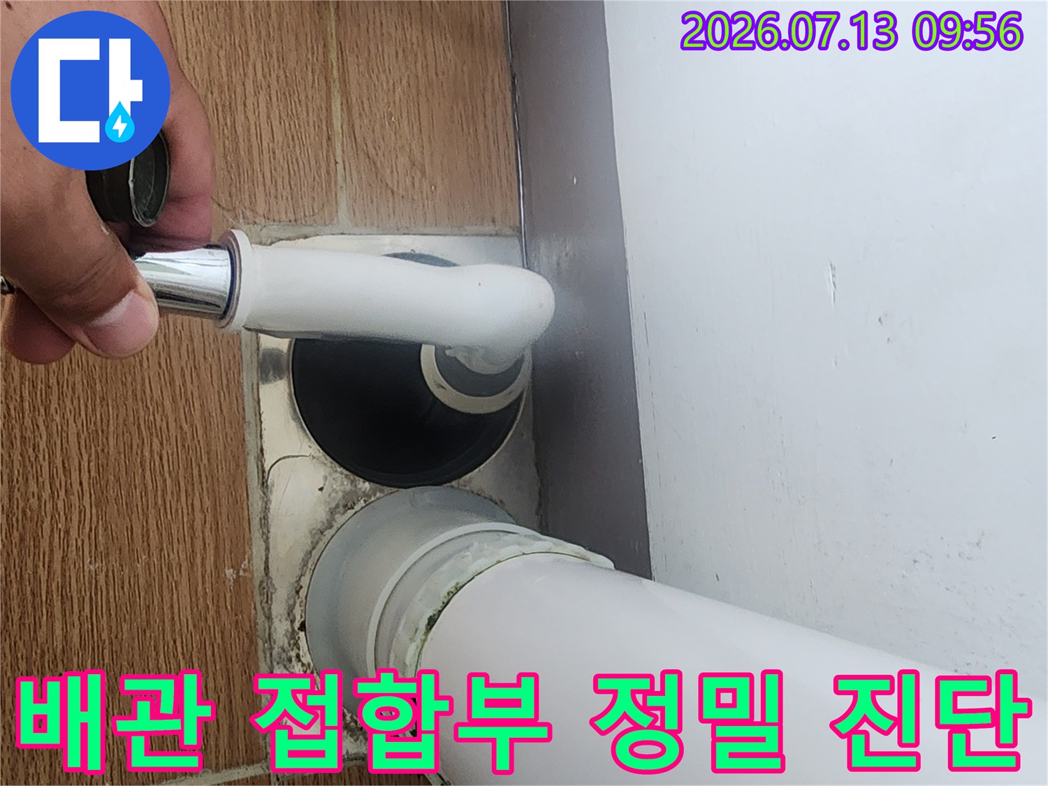 전문가가 우수관 하단부의 누수 가능성을 꼼꼼하게 체크하는 모습