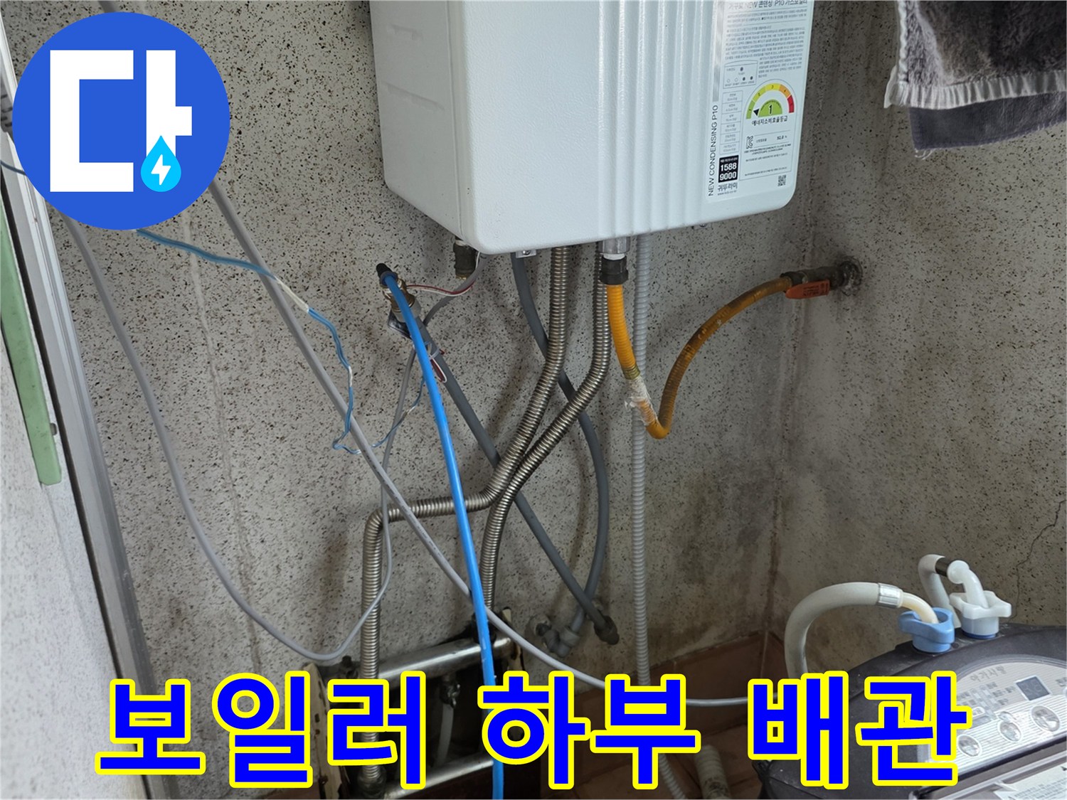 보일러 아래쪽의 다양한 배관들과 연결된 점검용 호스