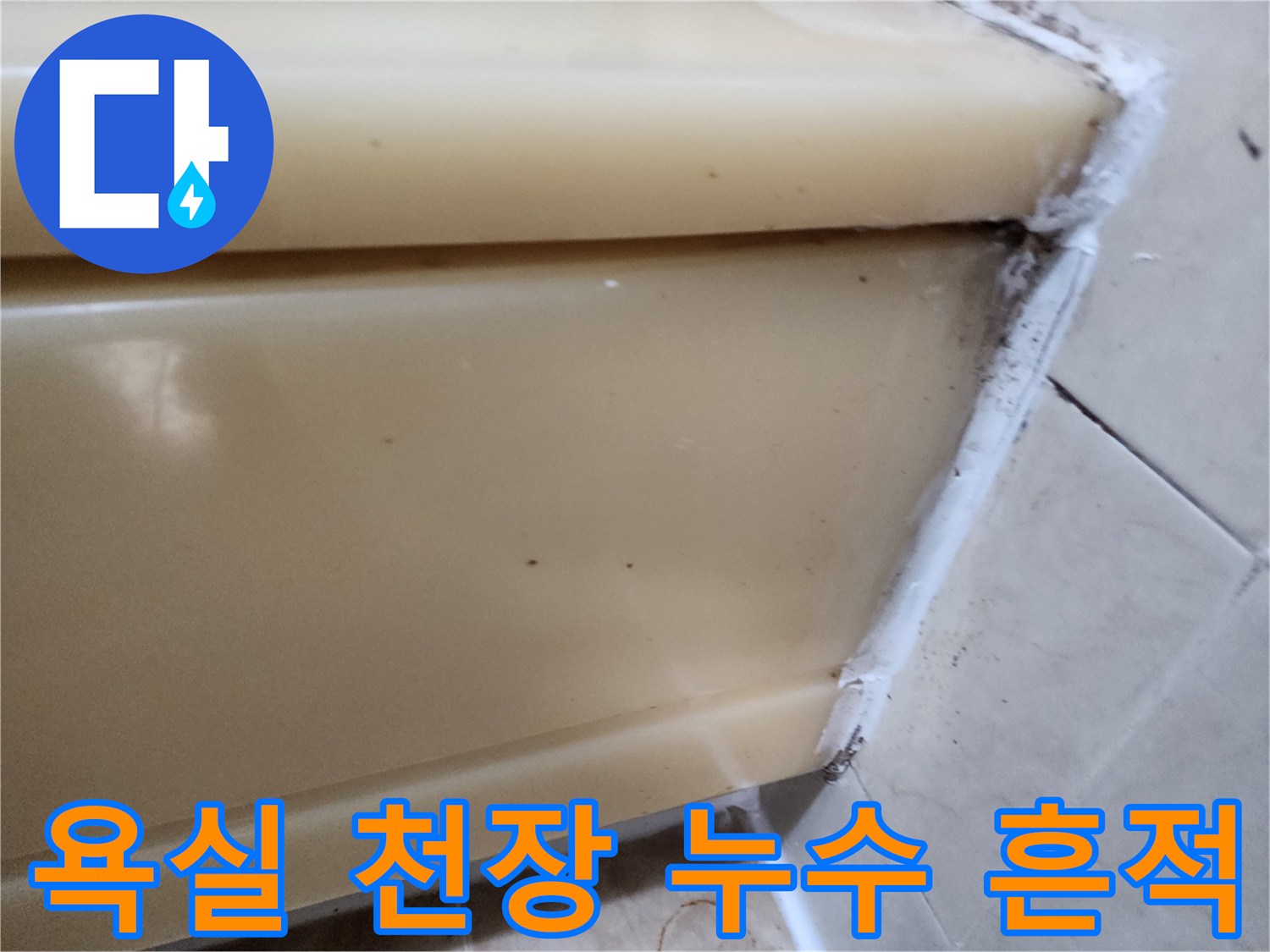 갈색 물자국이 남은 화장실 천장 패널과 타일 접합부