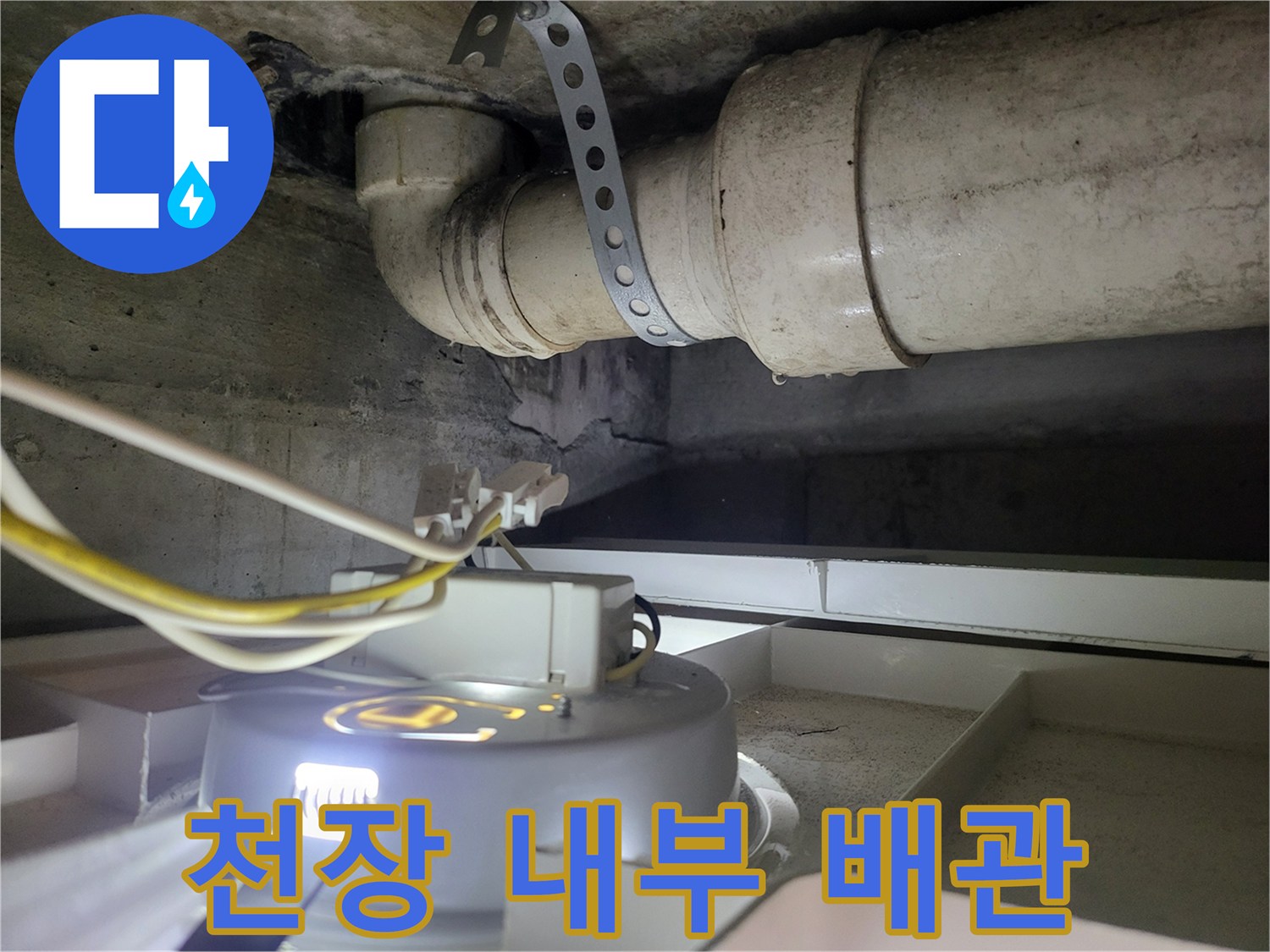 천장 배관과 고정 밴드 및 전선이 보이는 현장 사진입니다.