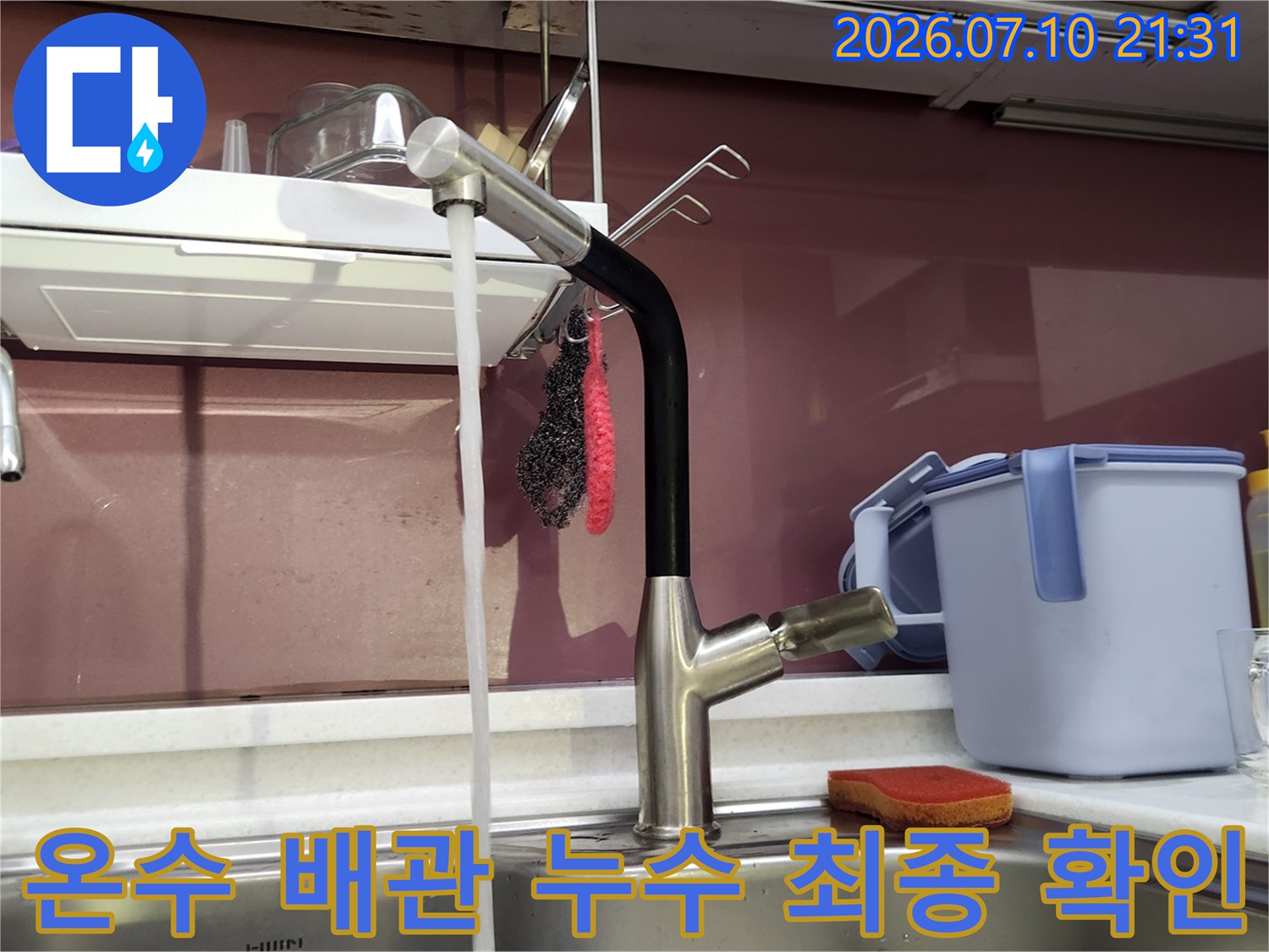 보수를 마친 싱크대 온수 배관과 수전 호스의 연결 상태를 점검하는 모습