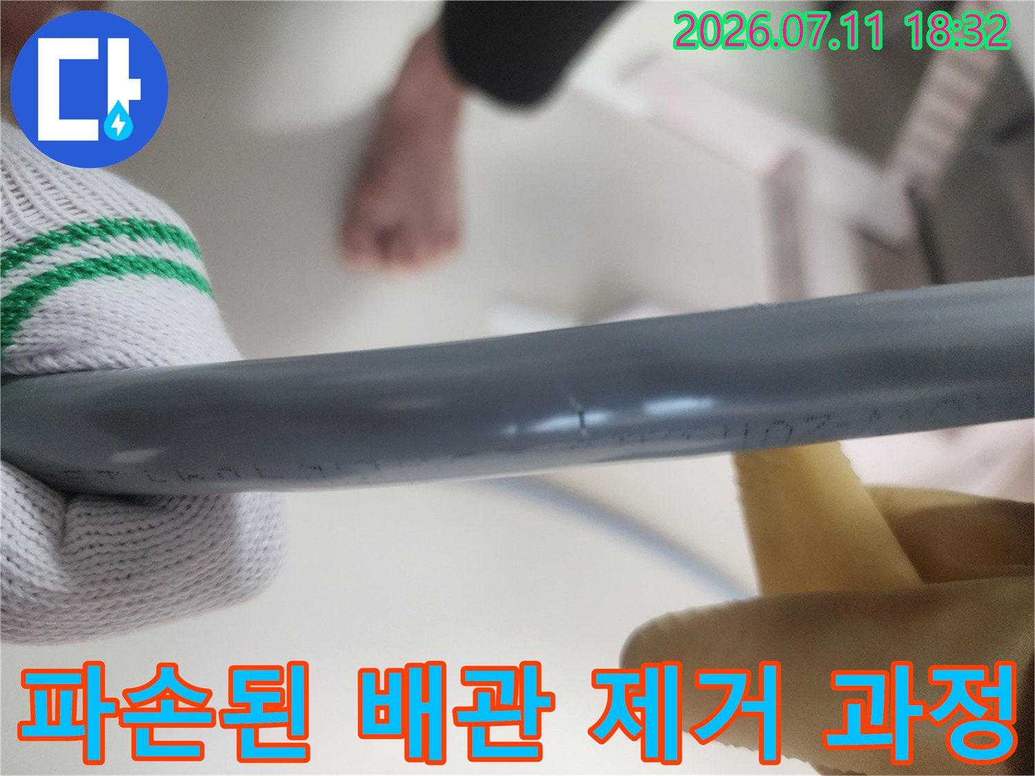 장갑을 낀 작업자가 노출된 직수 배관을 철거하는 모습