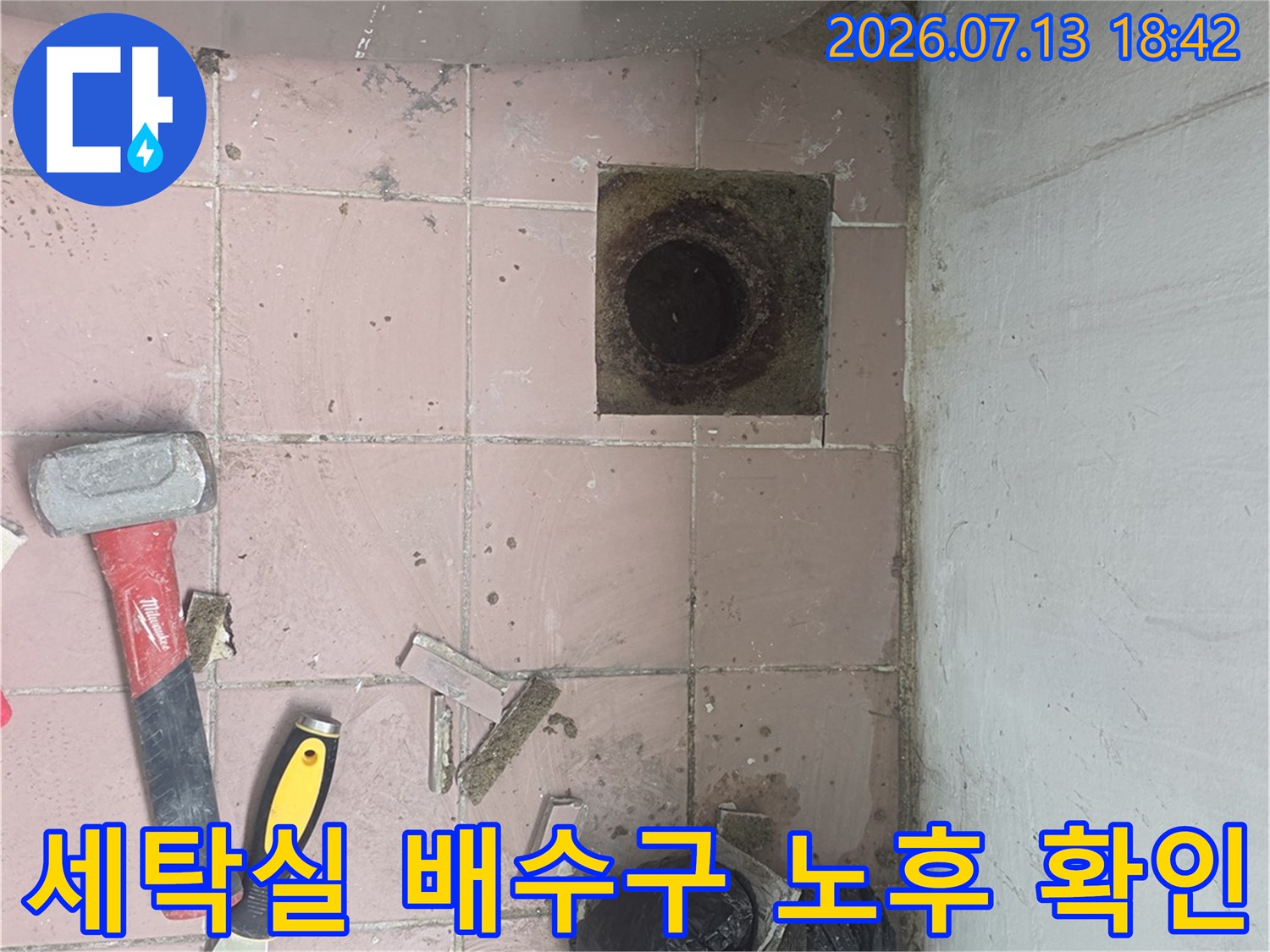 노출된 세탁실 하수구와 주변 타일의 상태를 촬영한 사진