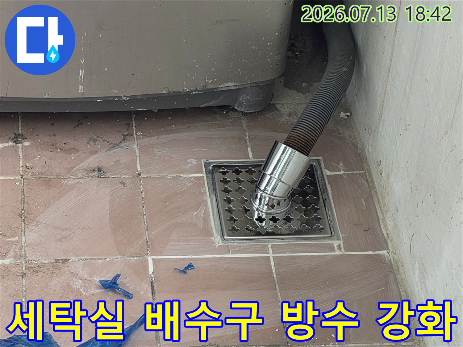 스테인리스 소재의 배수 트랩과 연결된 세탁 호스의 상세 모습