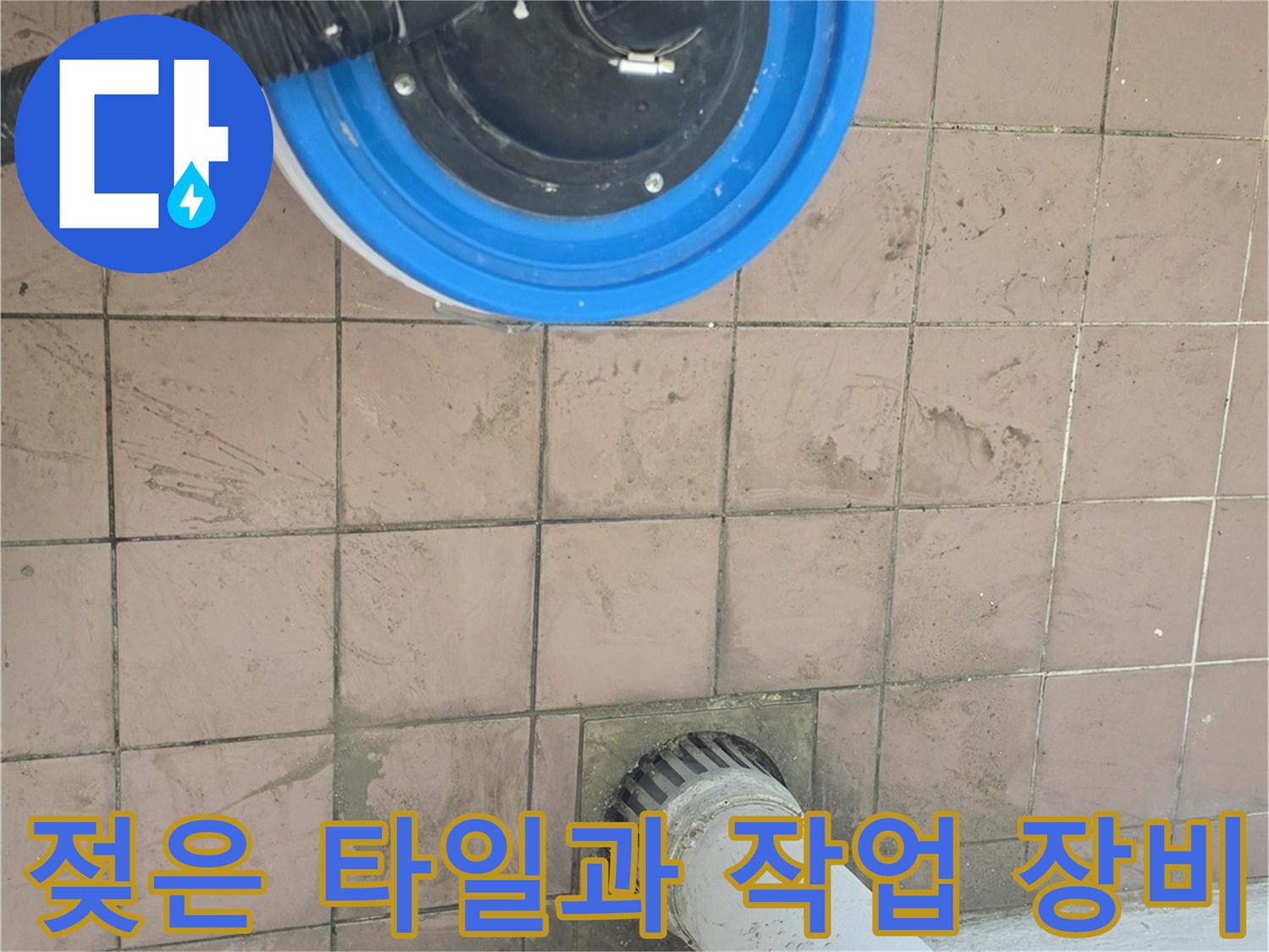 습기가 감지된 세탁실 바닥과 배수구 주변의 청소 도구