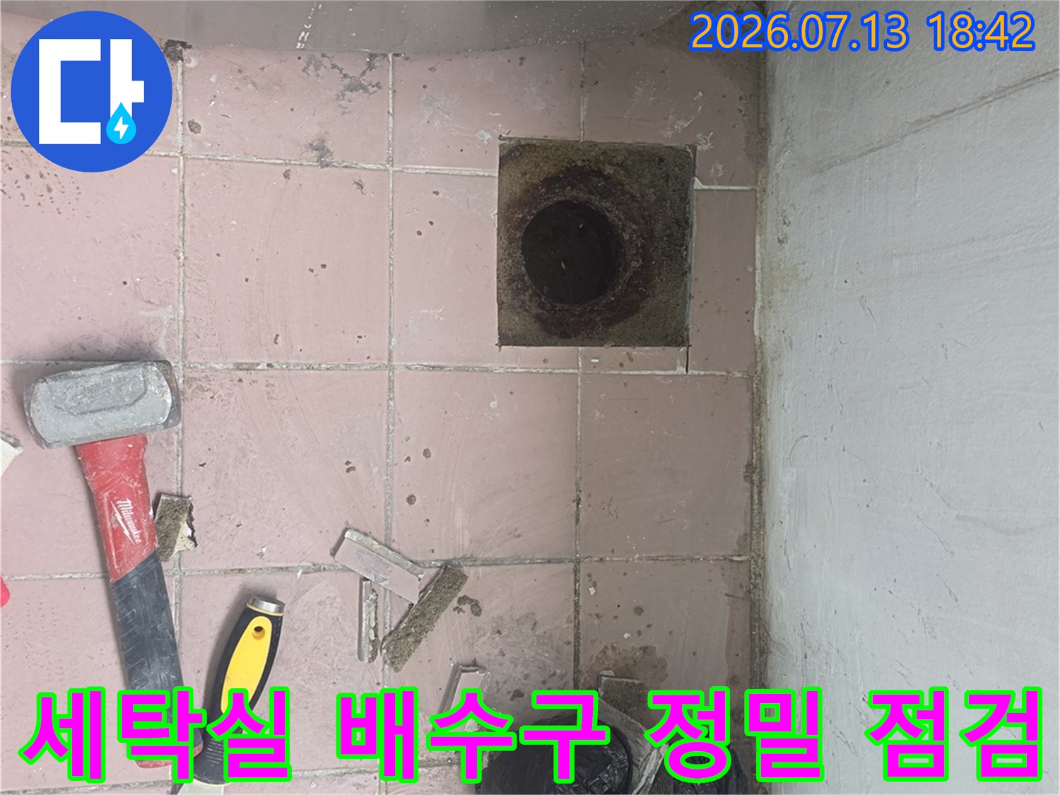 탈거된 세탁실 배수구 내부와 작업 도구가 놓인 현장 모습