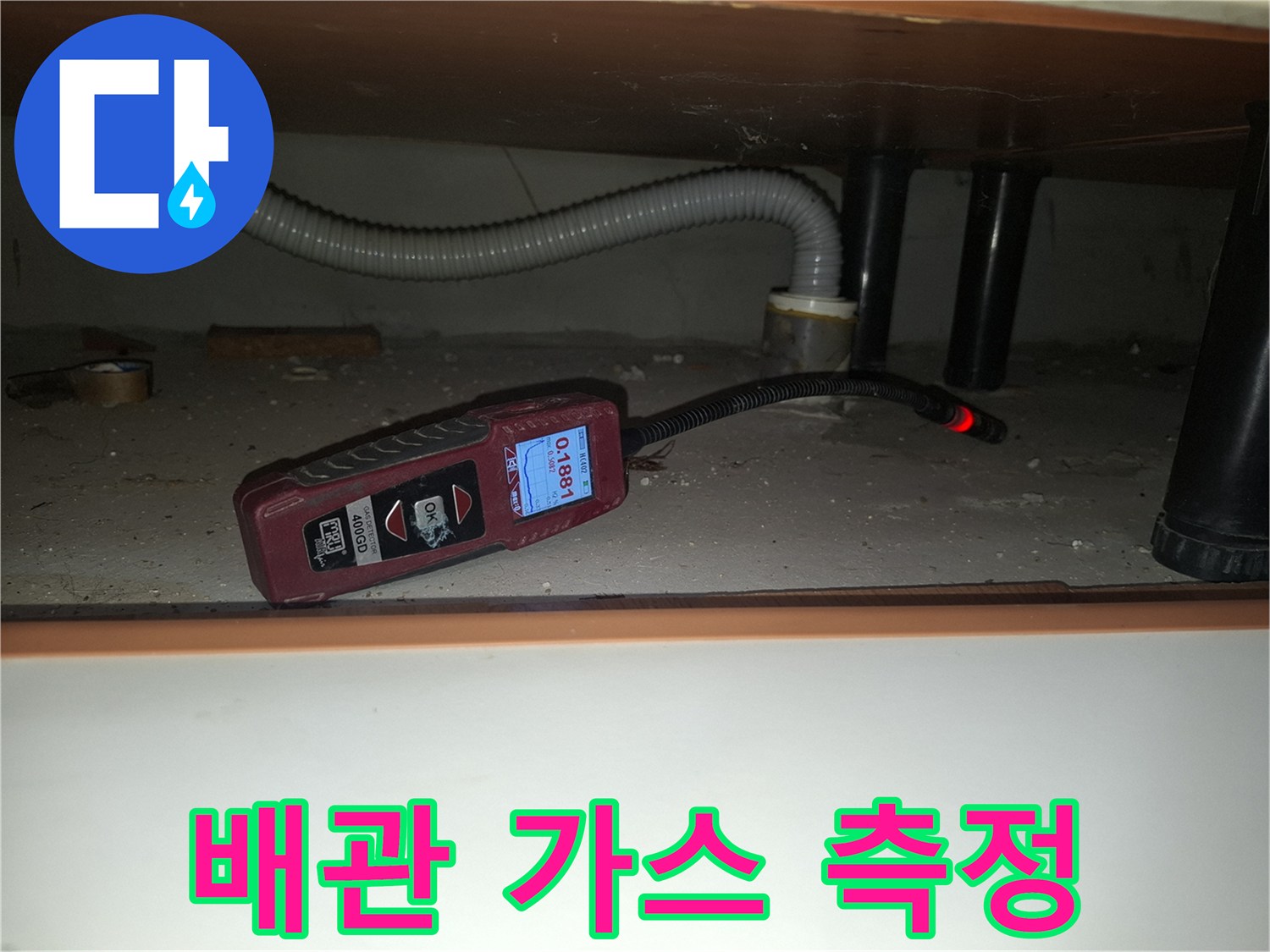 숫자가 표시된 휴대용 가스 탐지기로 누수 지점을 추적하는 장면입니다.