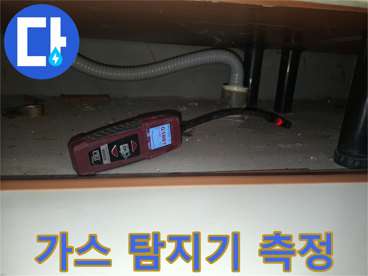 싱크대 하부 공간에서 가스 탐지기로 수치를 확인하는 모습