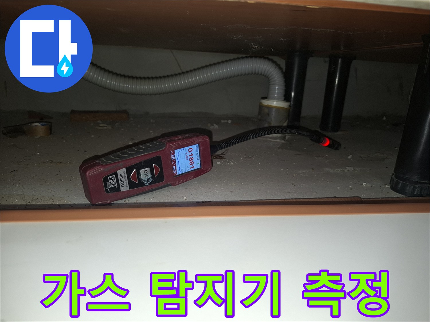 싱크대 하부 배관 누수를 찾기 위해 가스 탐지기를 사용하는 모습입니다.
