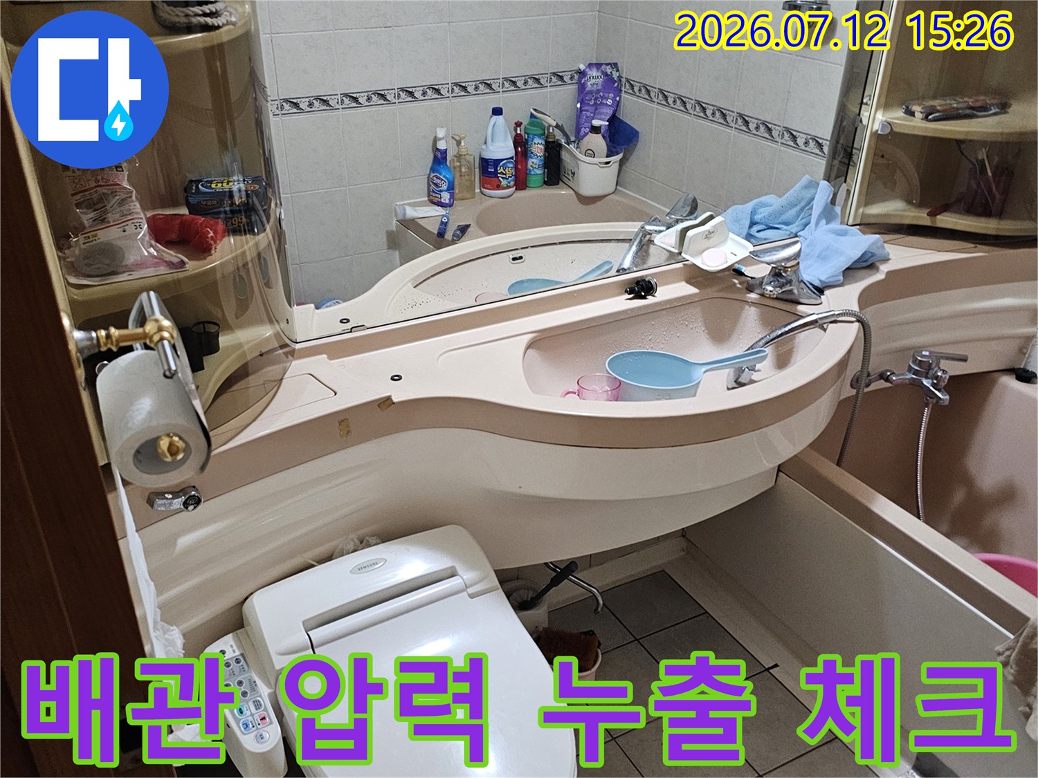 화장실 내 배관을 연결한 호스와 측정 장비의 모습