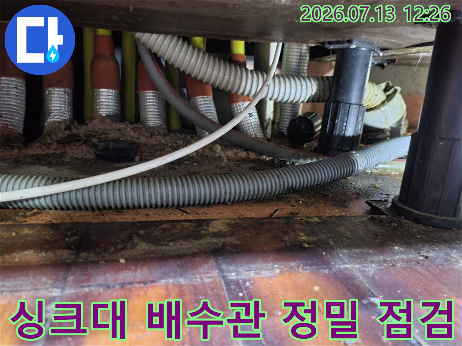 싱크대 하부의 굴곡진 배수관과 연결 부위를 내시경으로 점검하는 모습